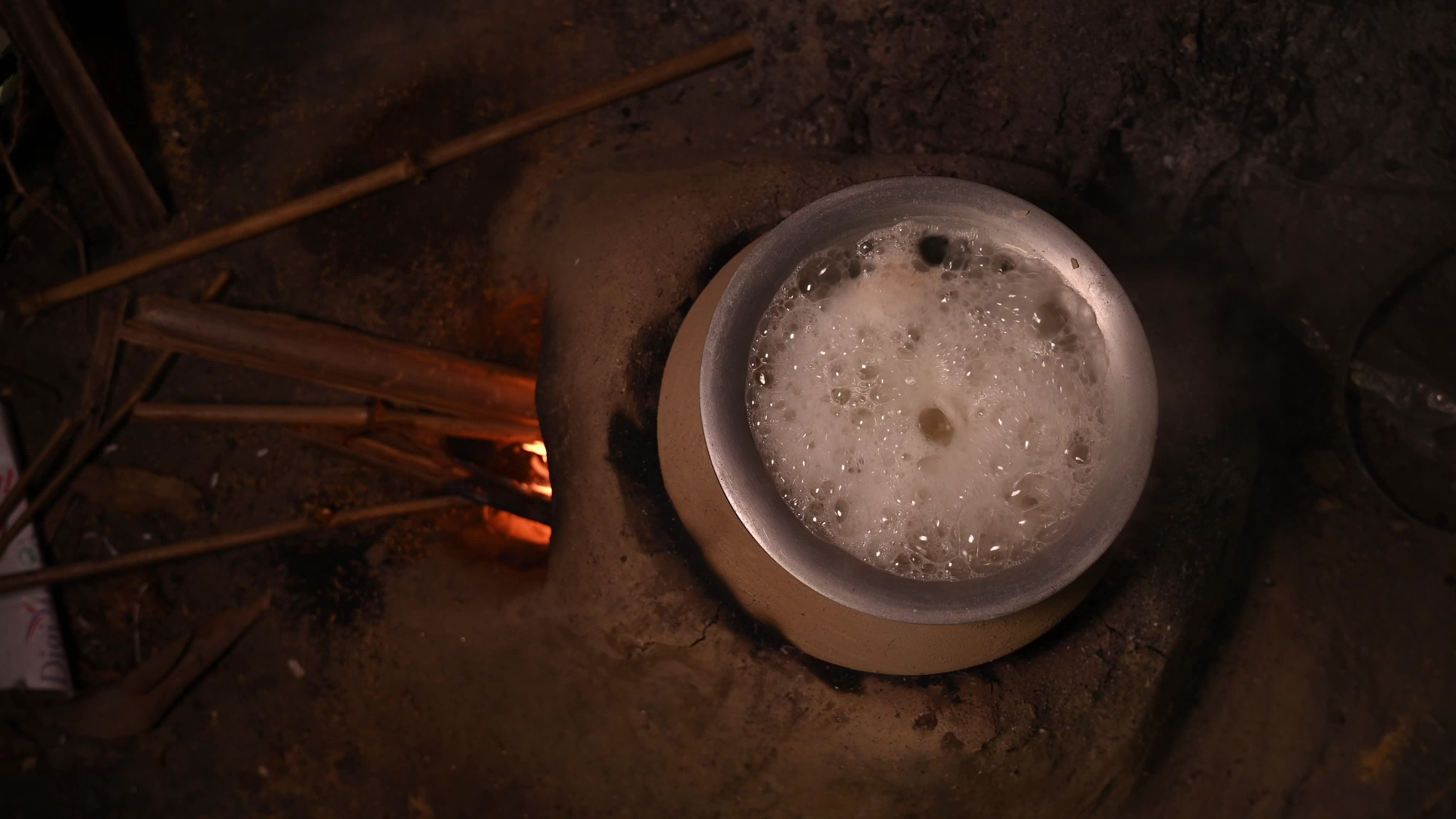 Cooking in an Old-fashioned wood-fired mud stove in India 