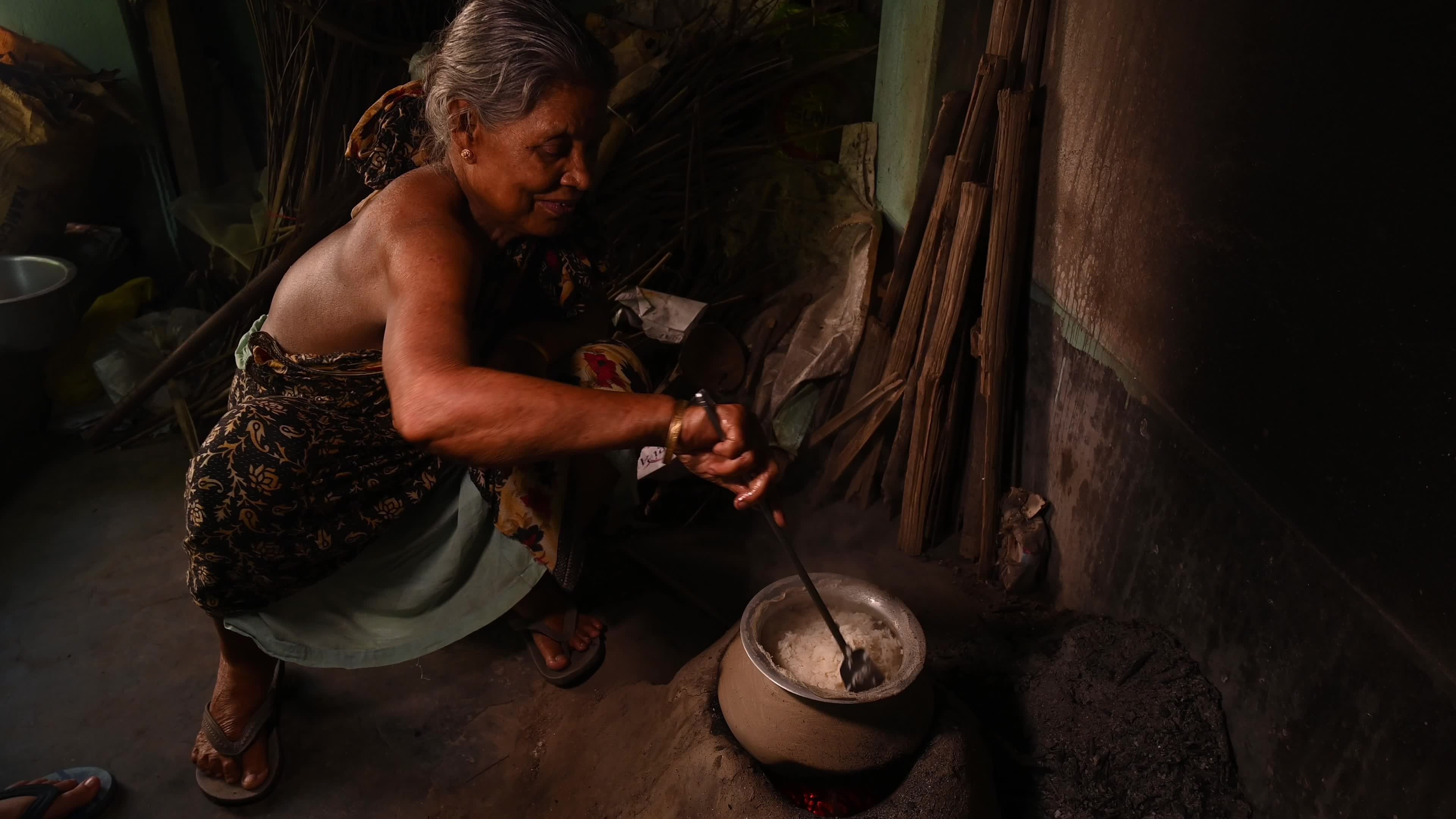 Cooking in an Old-fashioned wood-fired mud stove in India 