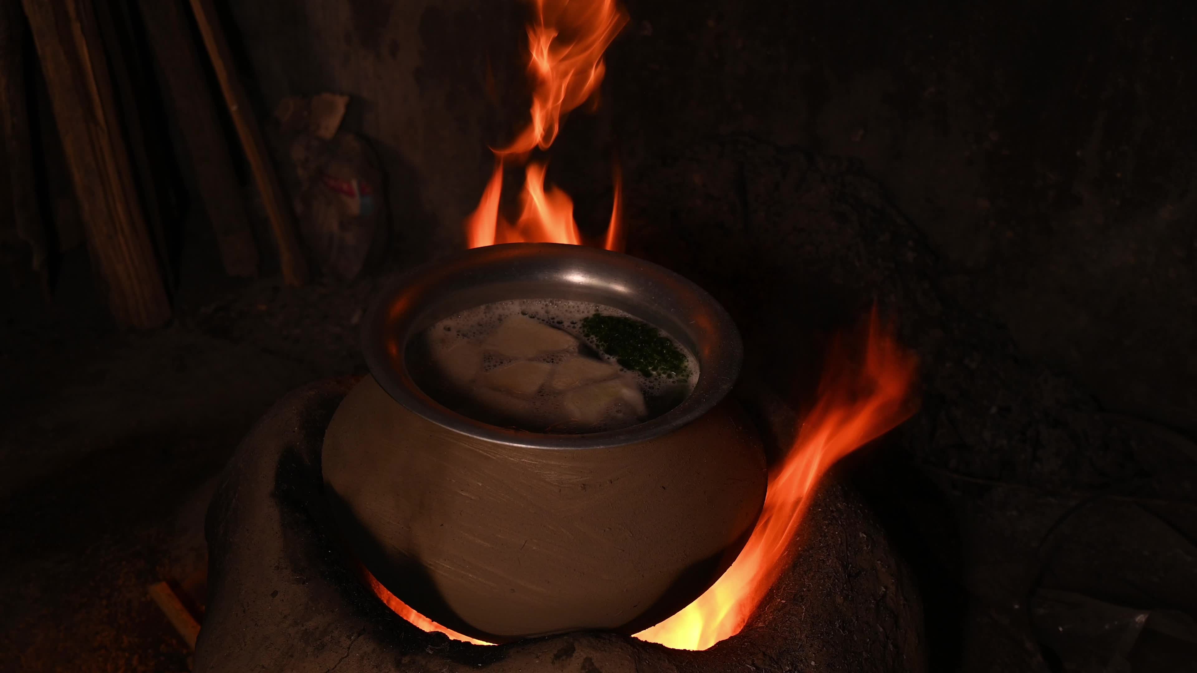Cooking in an Old-fashioned wood-fired mud stove in India 