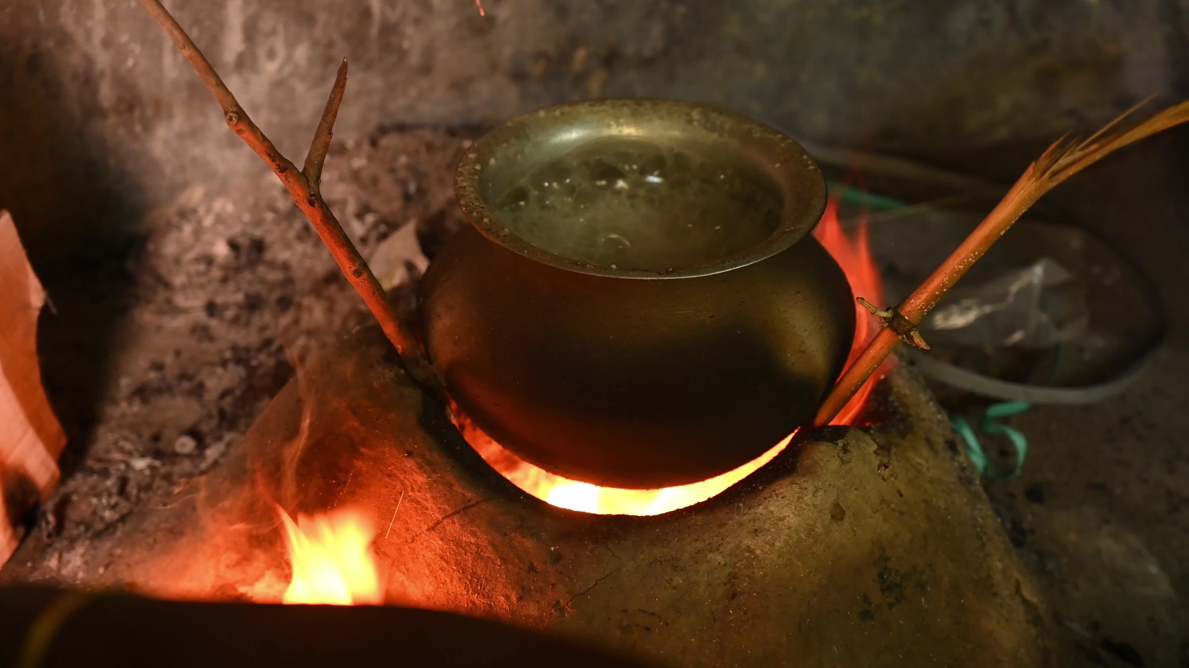 Cooking in an Old-fashioned wood-fired mud stove in India 
