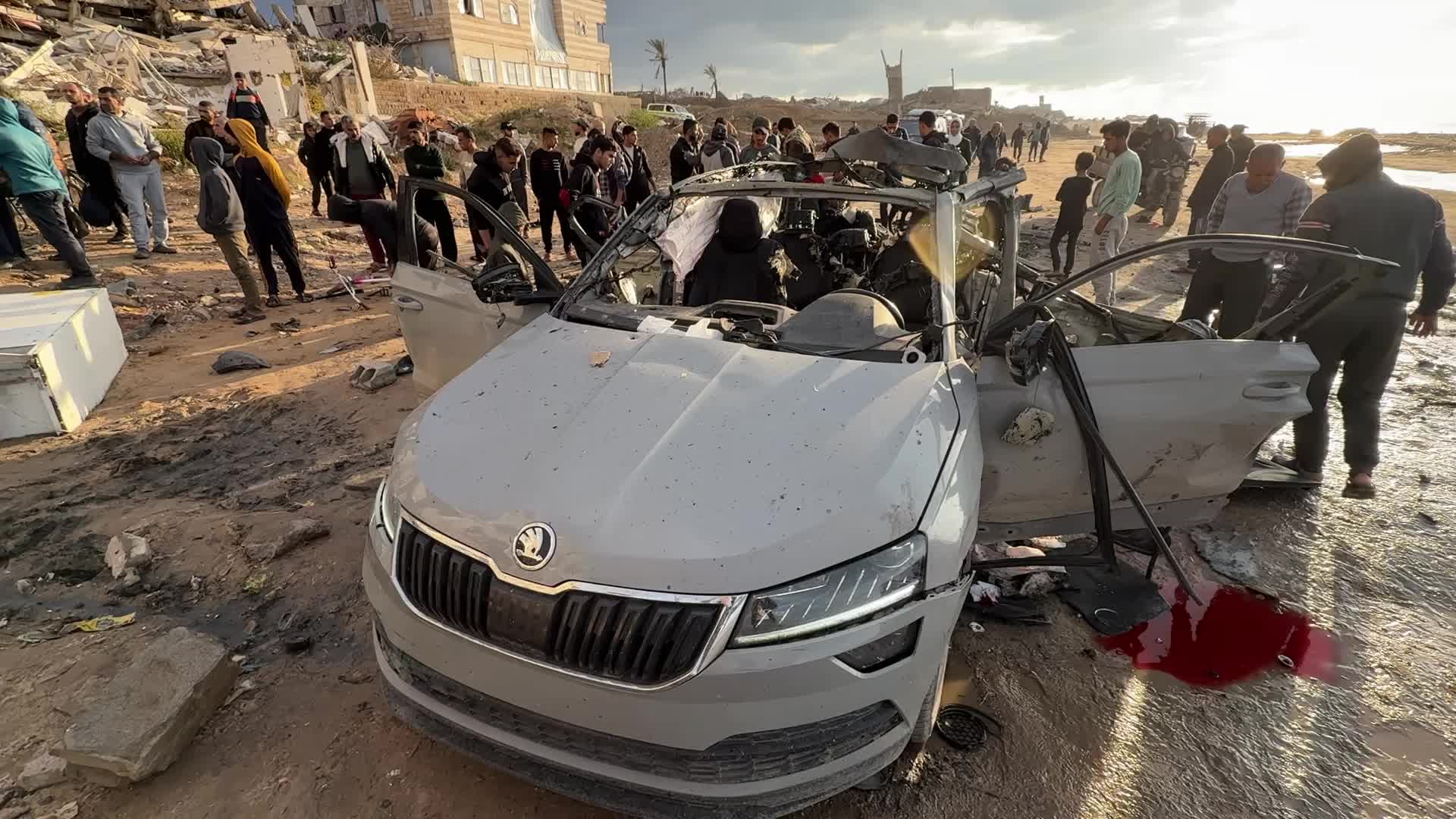 Palestinians Inspect Car After Israeli Strike in Gaza City