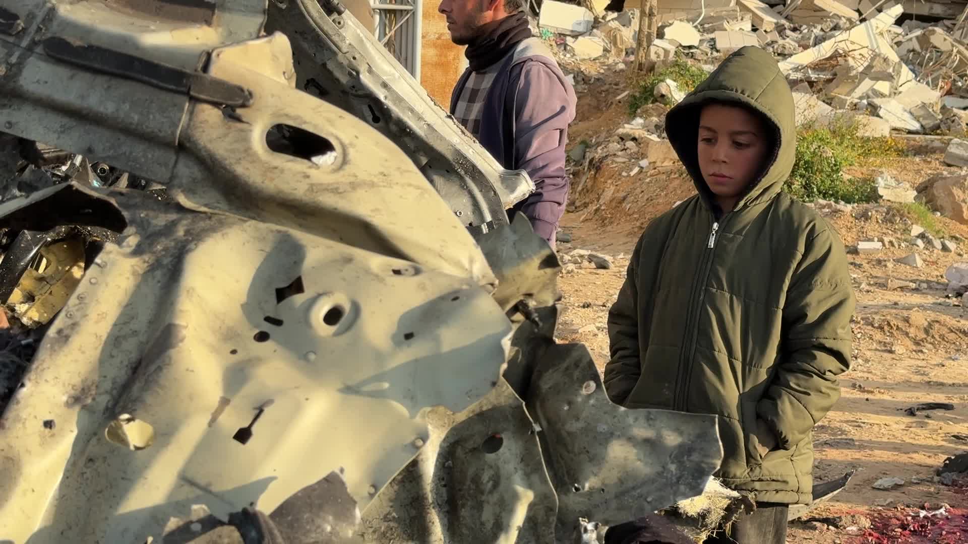 Palestinians Inspect Car After Israeli Strike in Gaza City