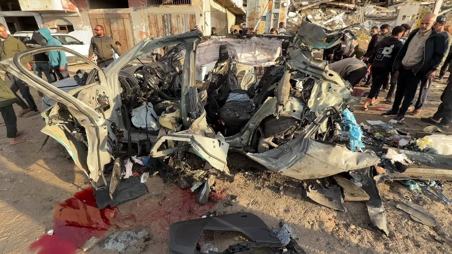Palestinians Inspect Car After Israeli Strike in Gaza City