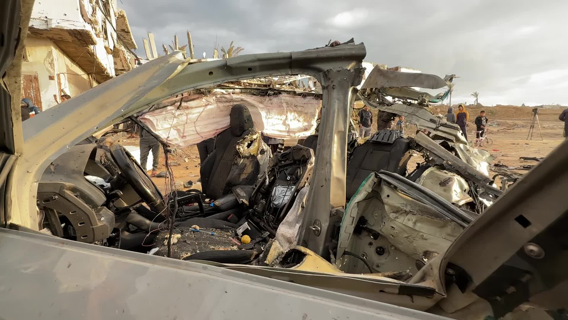 Palestinians Inspect Car After Israeli Strike in Gaza City