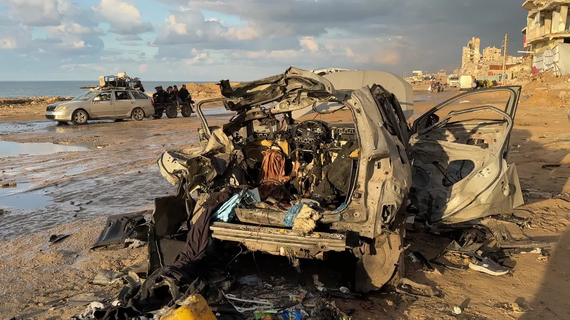 Palestinians Inspect Car After Israeli Strike in Gaza City