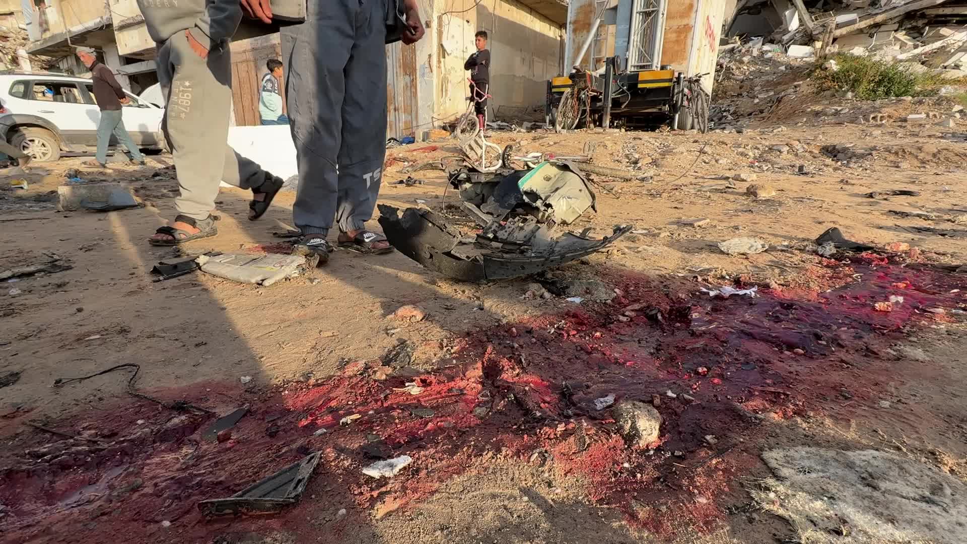 Palestinians Inspect Car After Israeli Strike in Gaza City