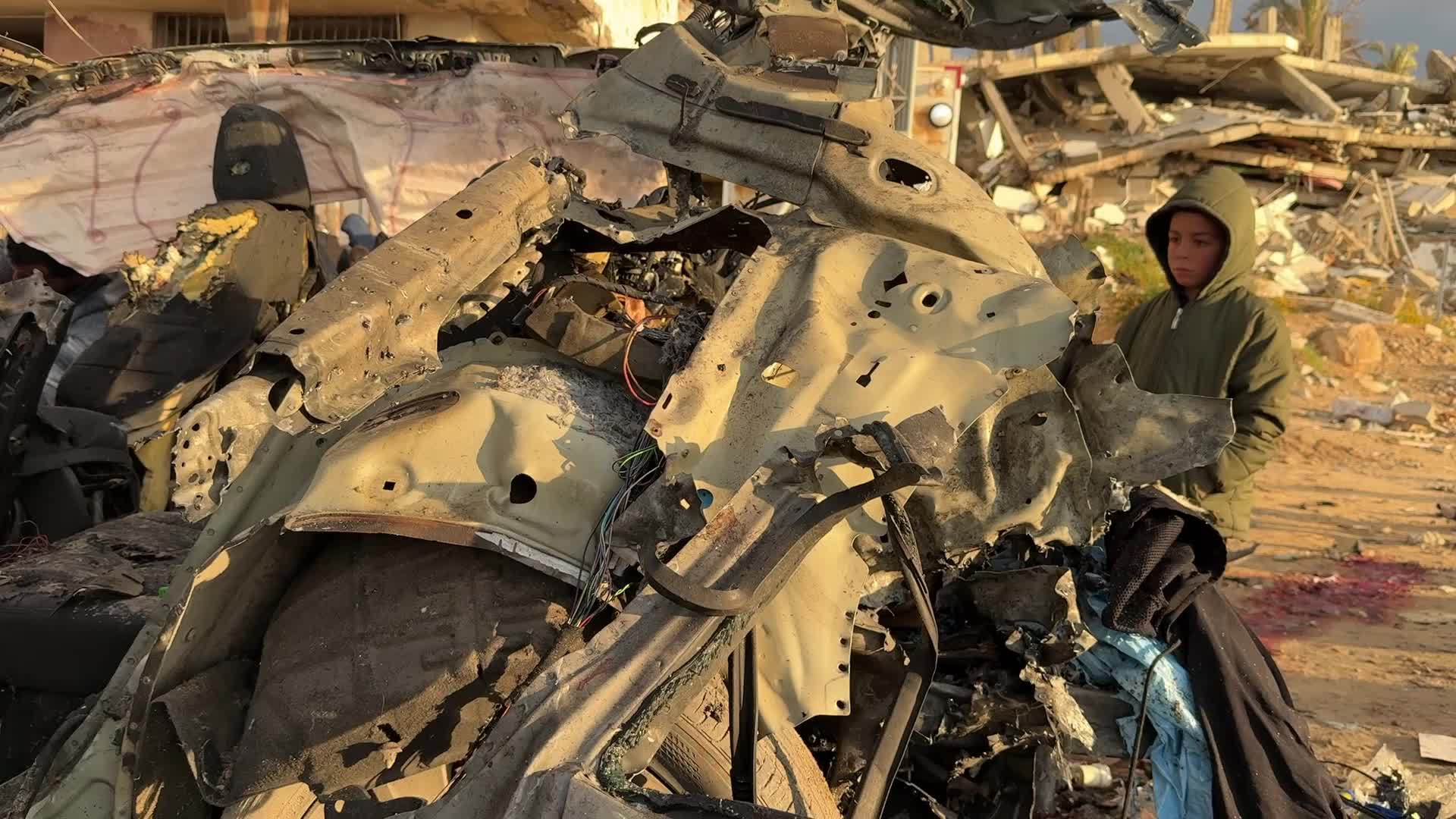 Palestinians Inspect Car After Israeli Strike in Gaza City