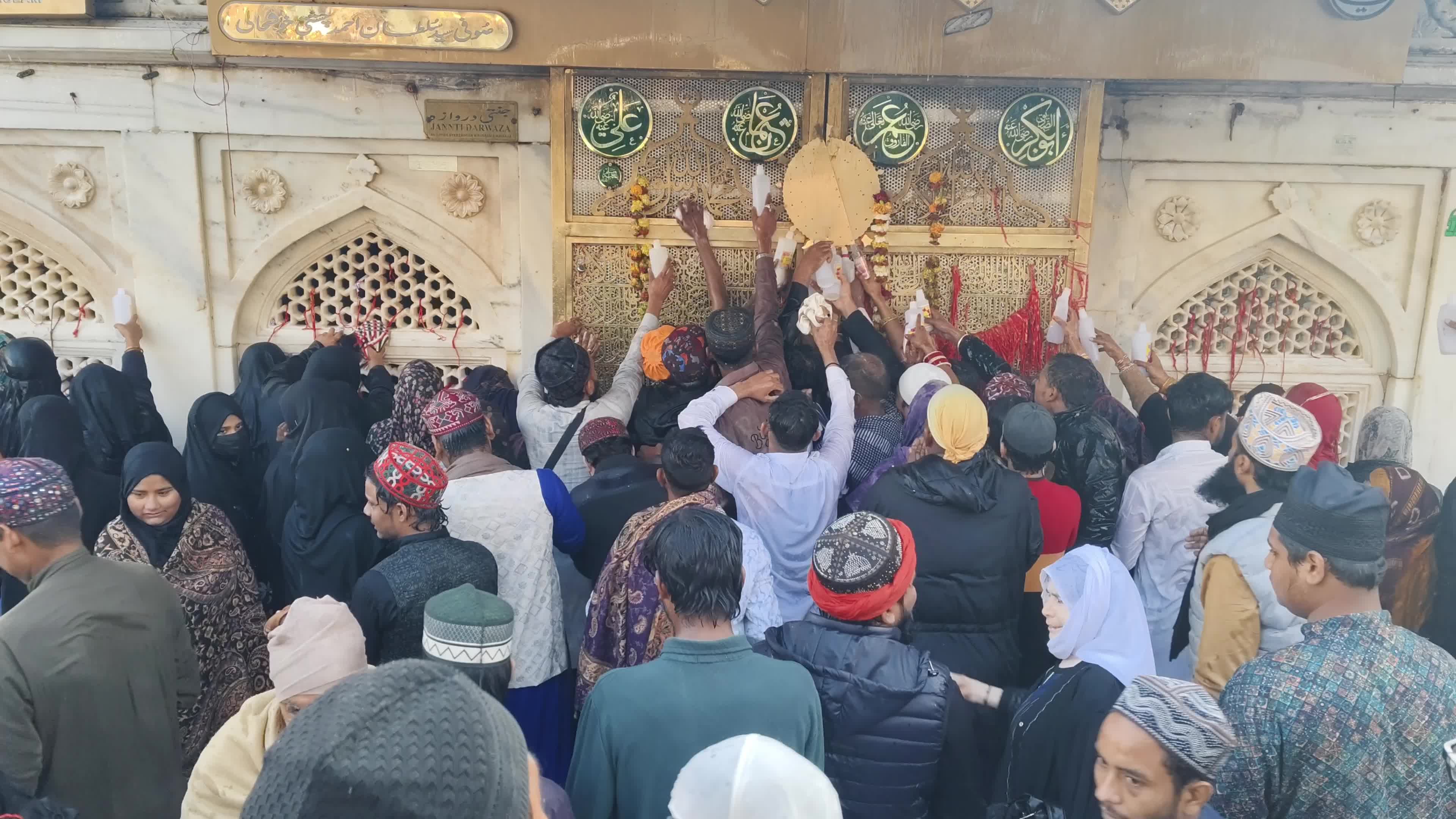 Devotees are showered with perfumed water during the end of the Urs festival