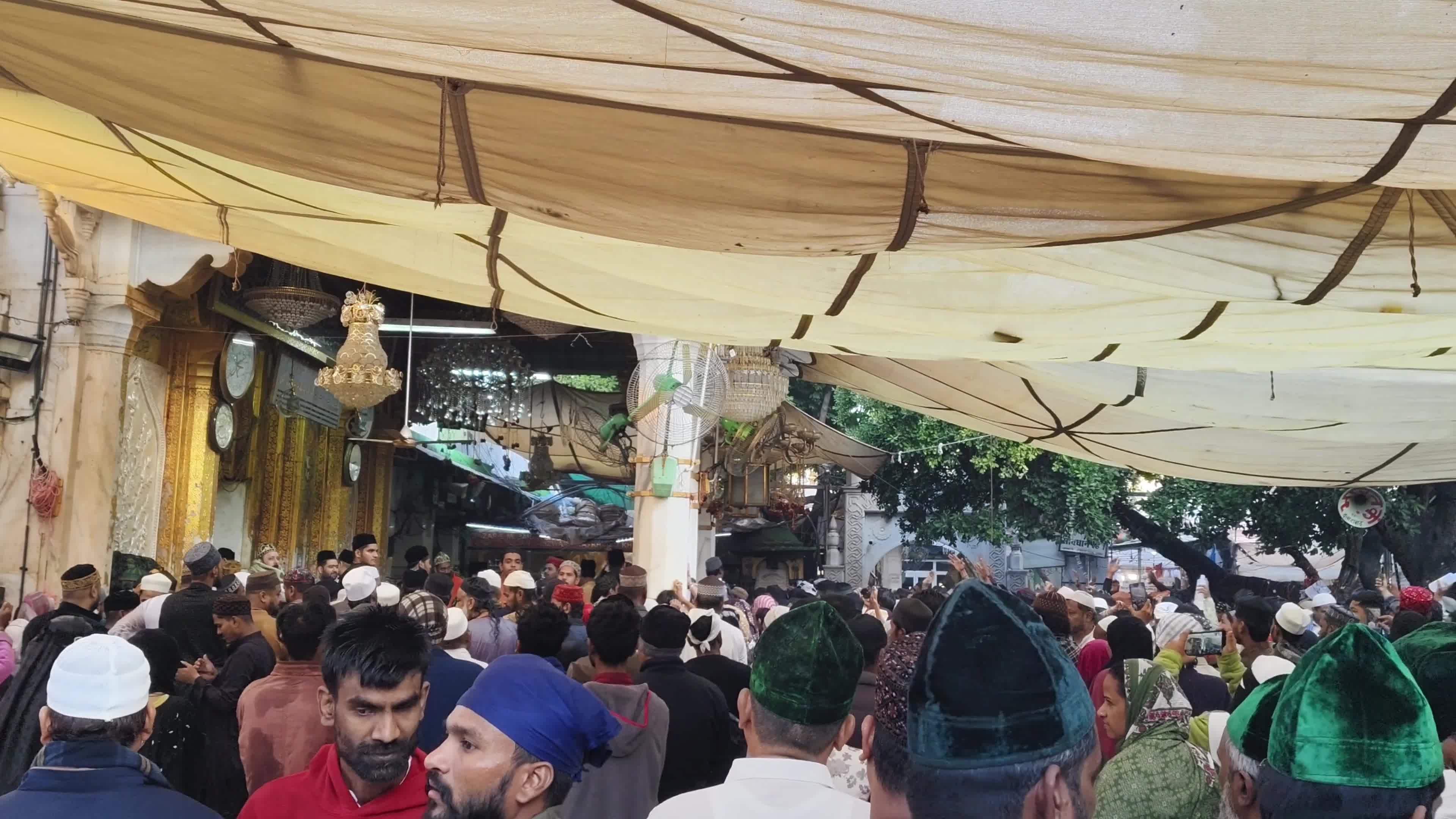 Devotees are showered with perfumed water during the end of the Urs festival