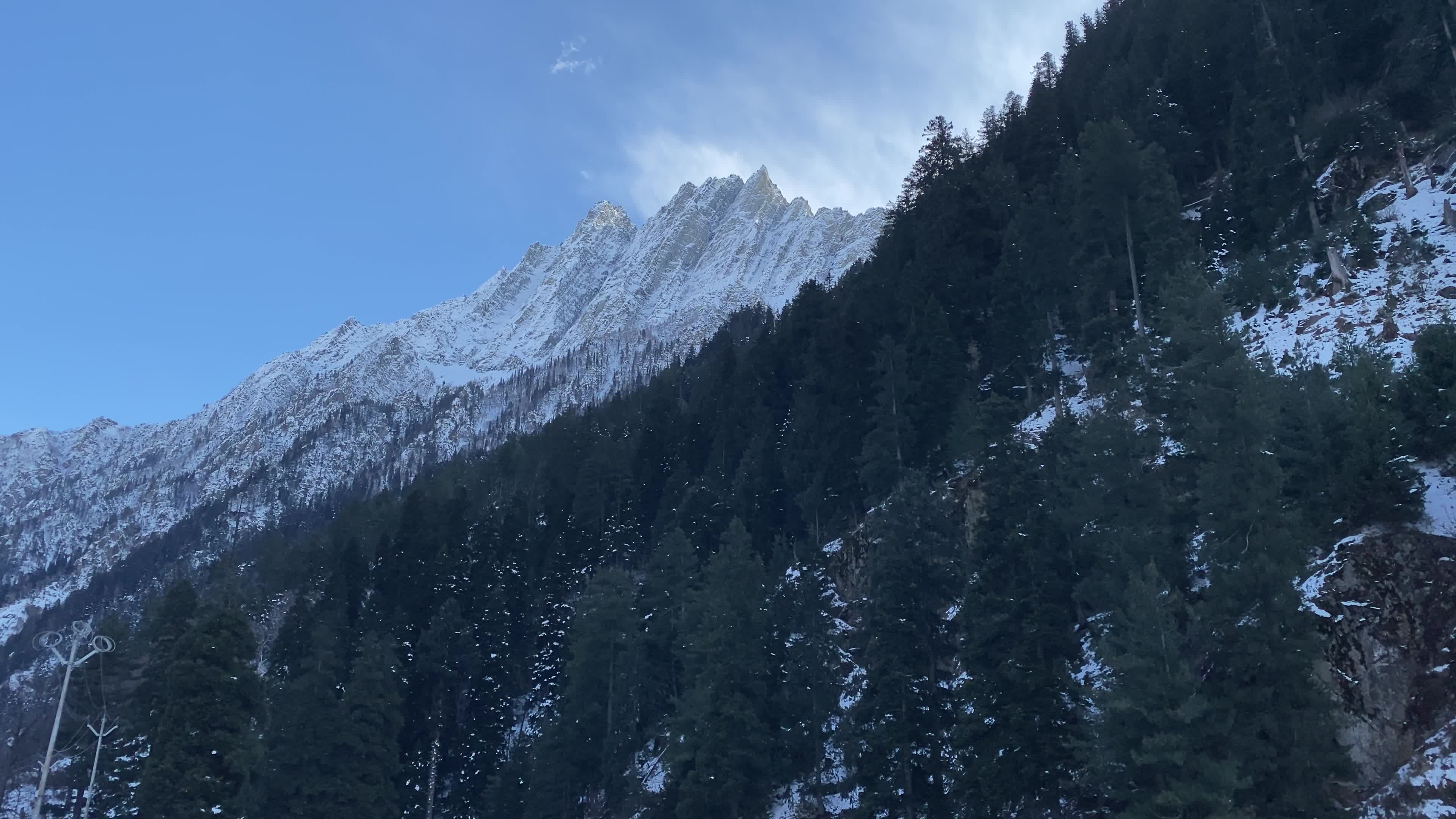 A view of partially snow covered mountains during winter.