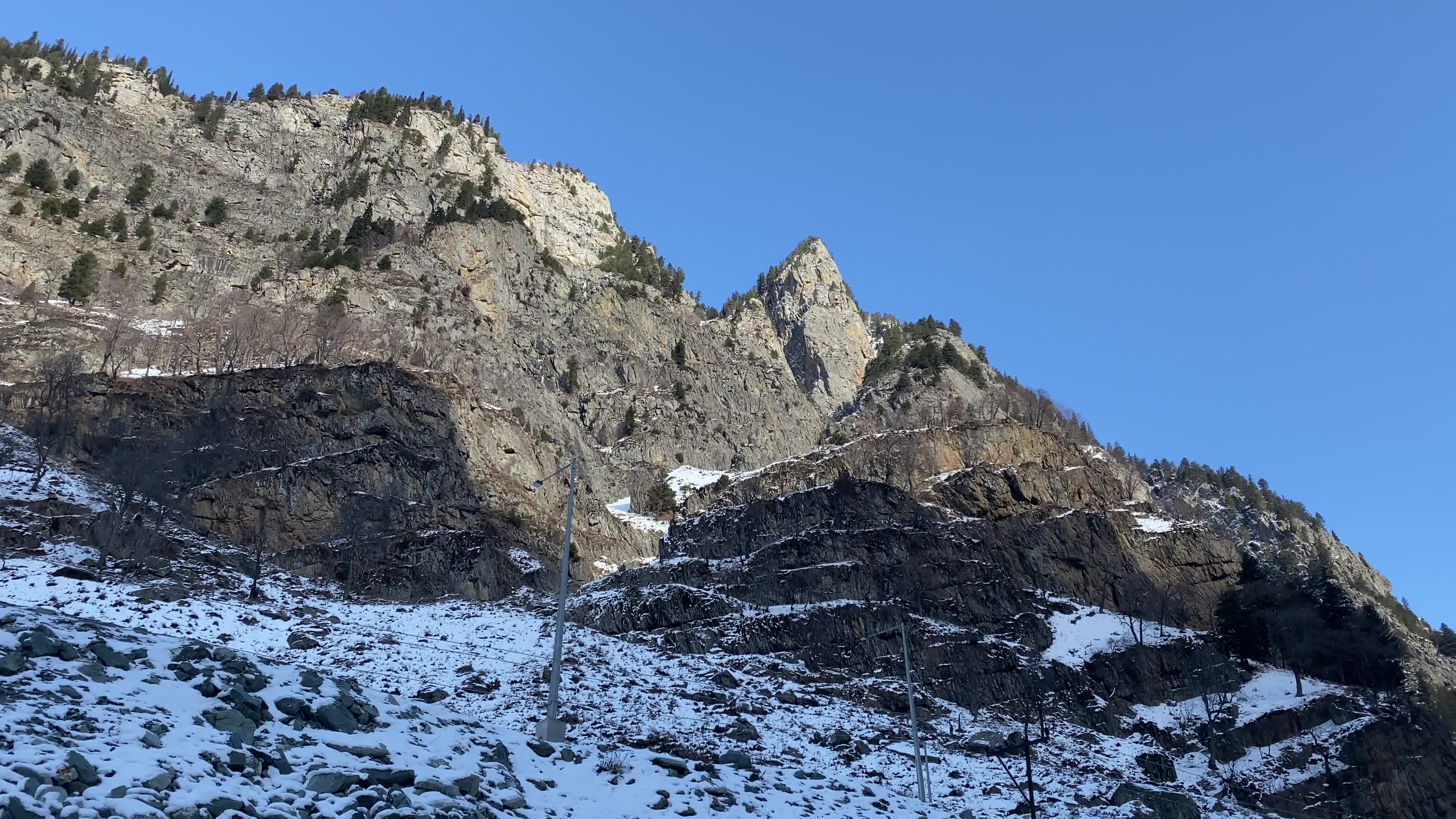 A view of partially snow covered mountains during winter.