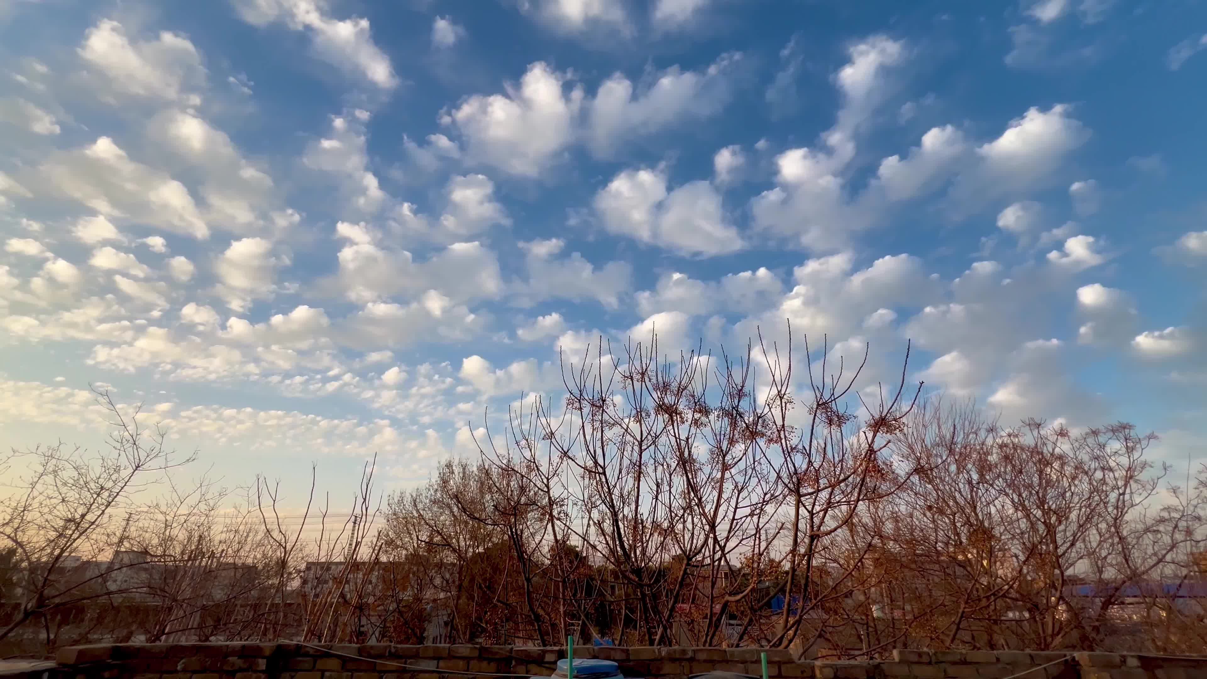 Sun sets beneath scattered clouds