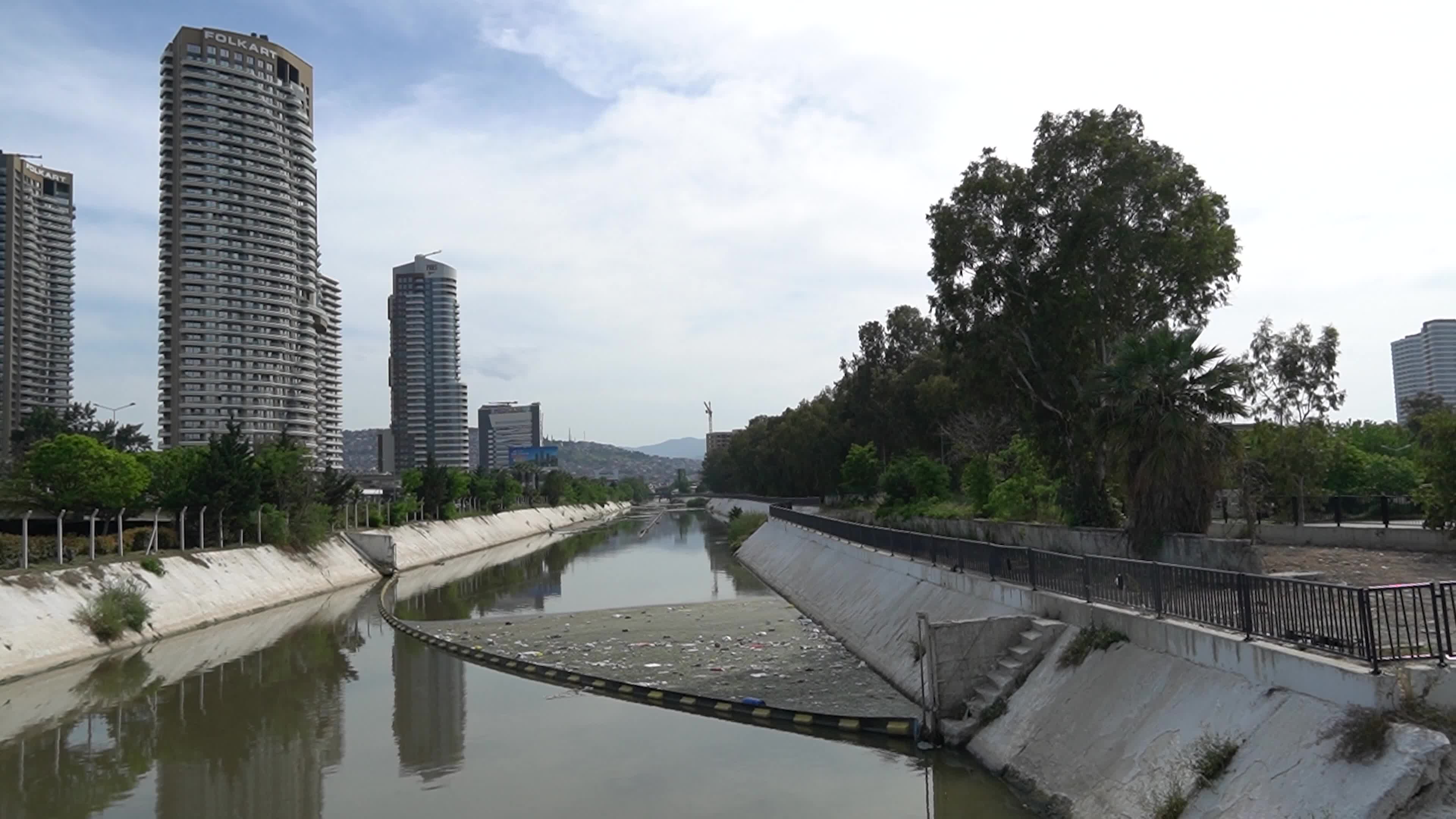 Trash and plastic bottles floating in a dirty city river