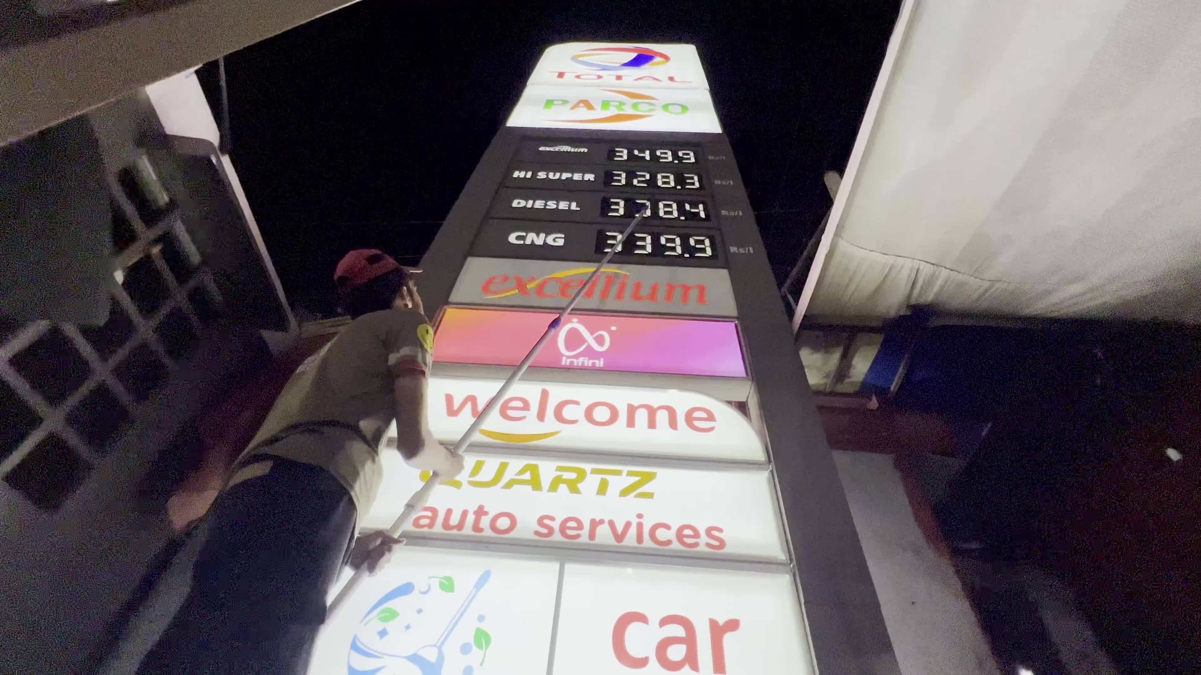 Petrol pump attendants stand beside covered fuel dispensers after fuel price hike in Peshawar