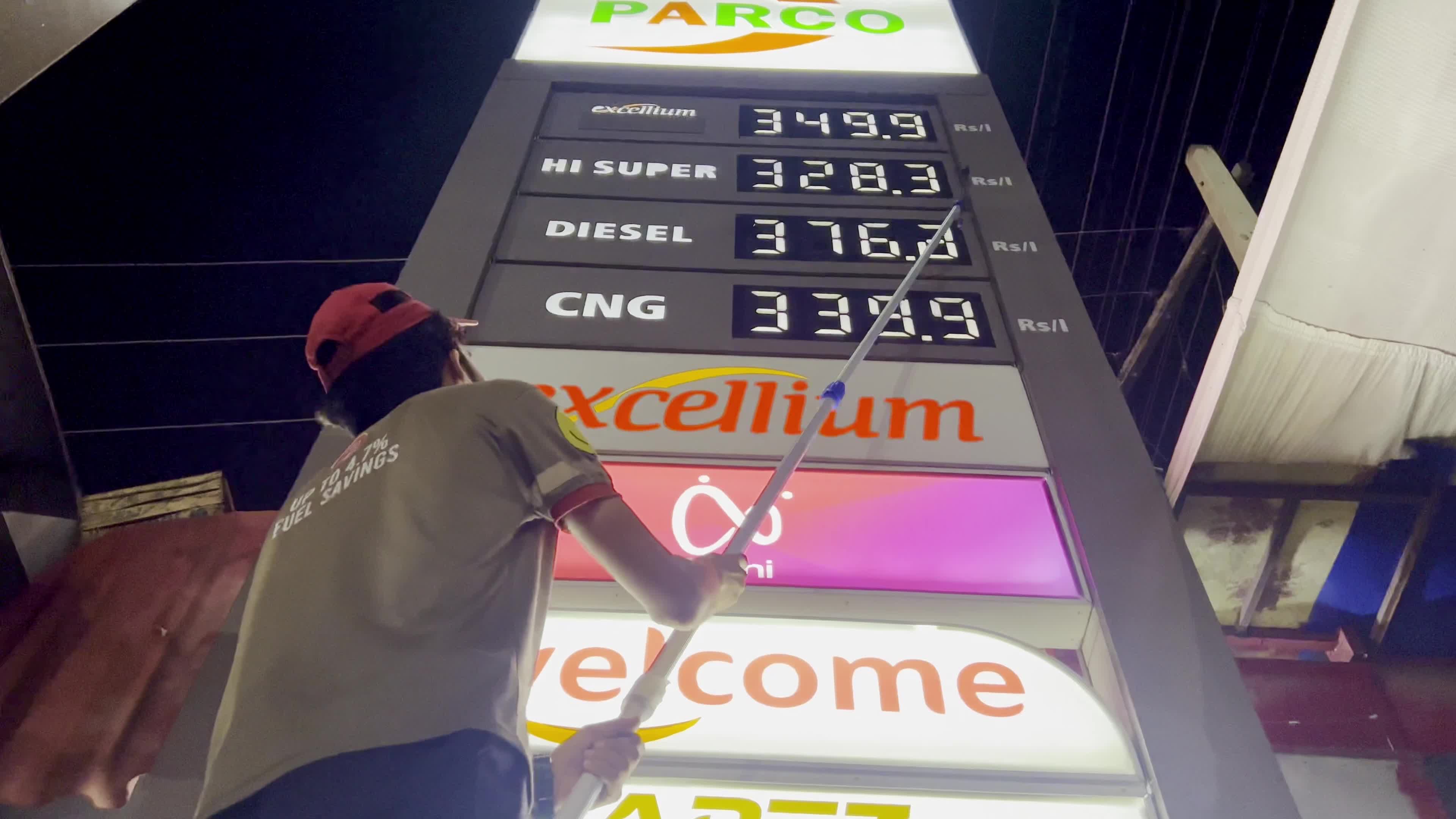 Petrol pump attendants stand beside covered fuel dispensers after fuel price hike in Peshawar