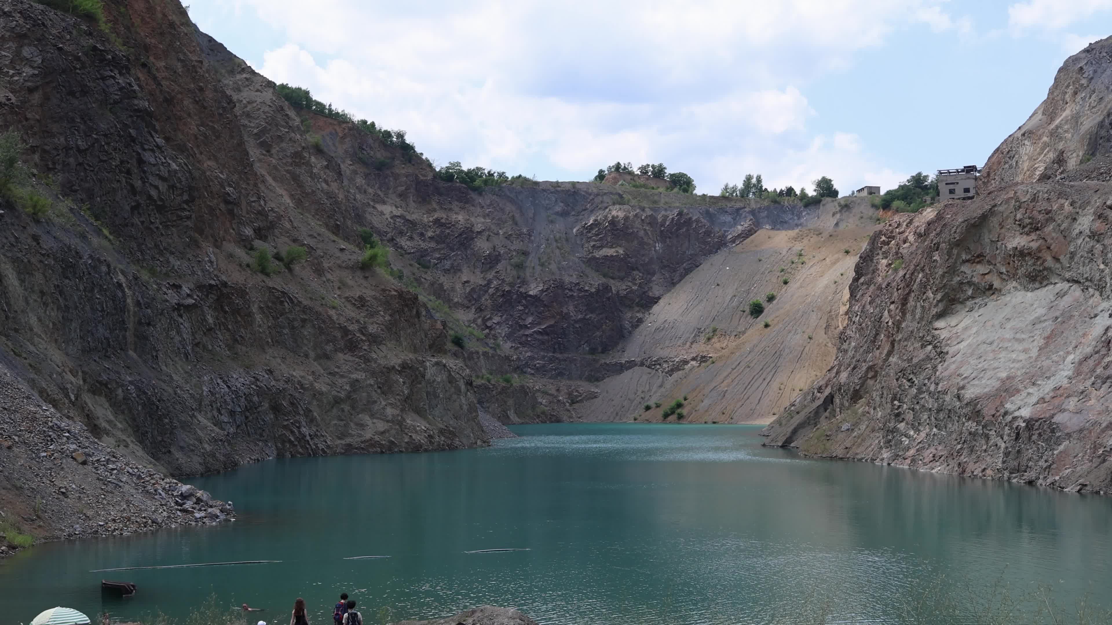Tourists at a Water-Filled Quarry Pit
