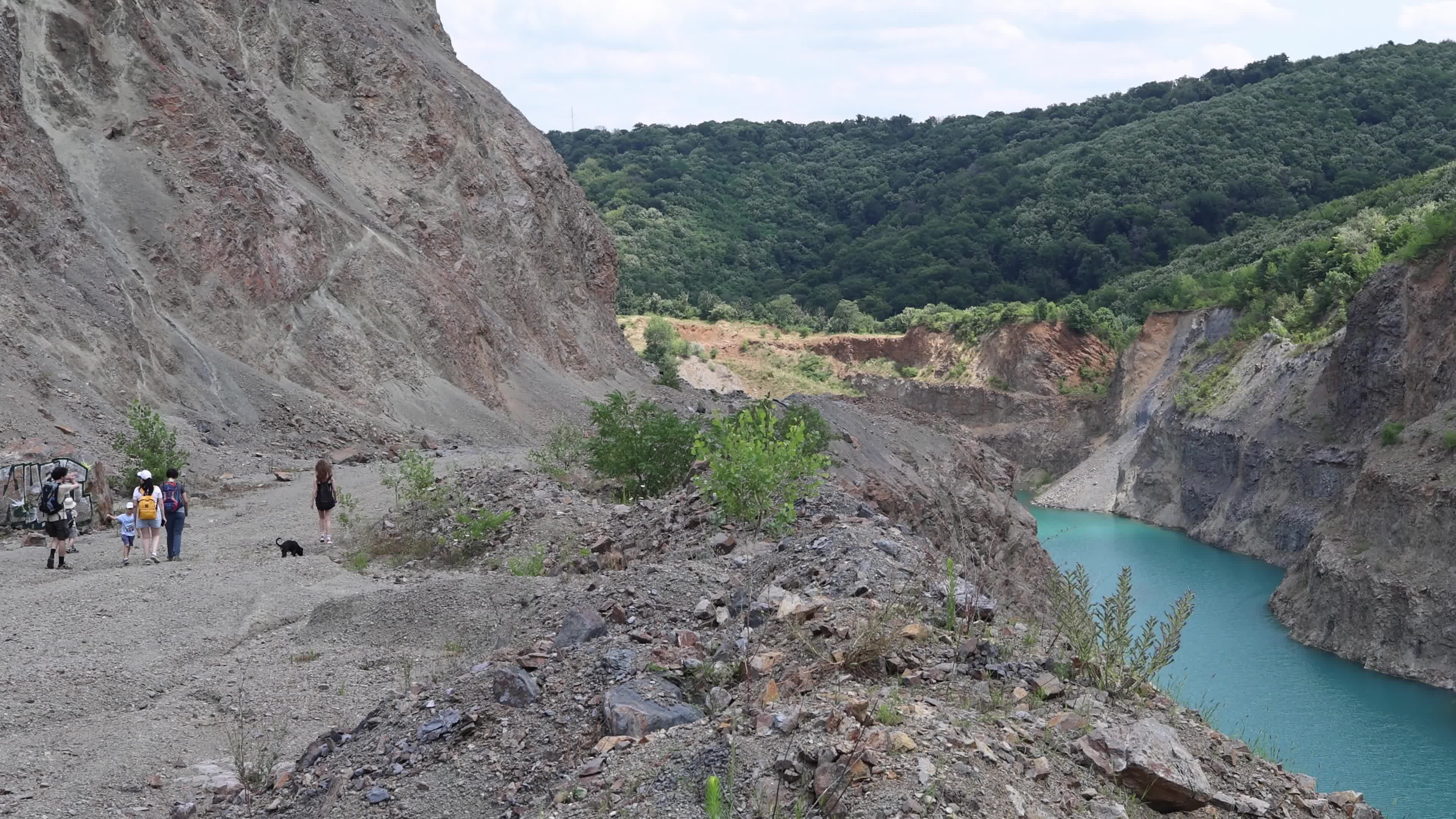 Tourists at a Water-Filled Quarry Pit