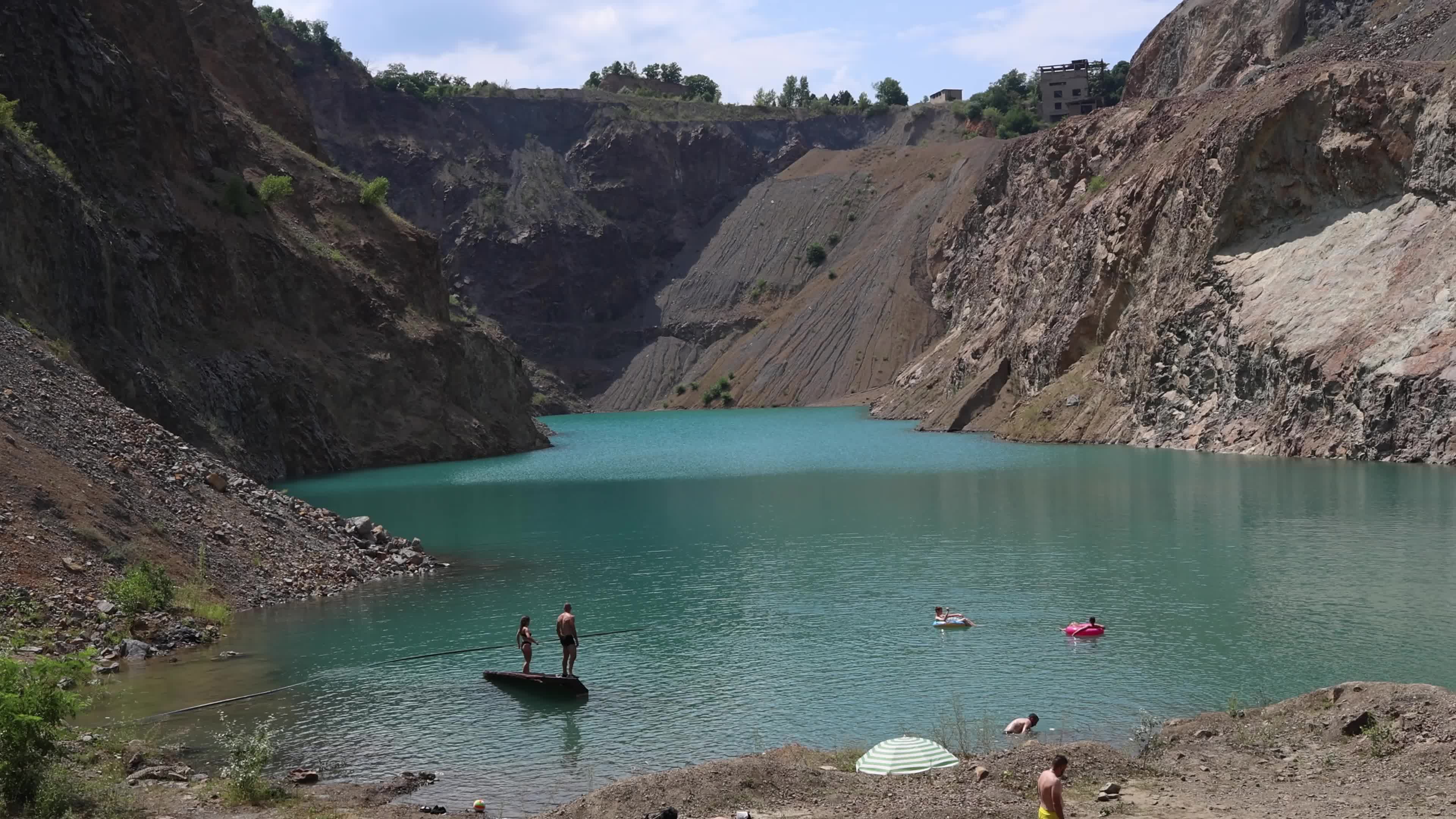 People Relaxing at a Water-Filled Quarry Pit
