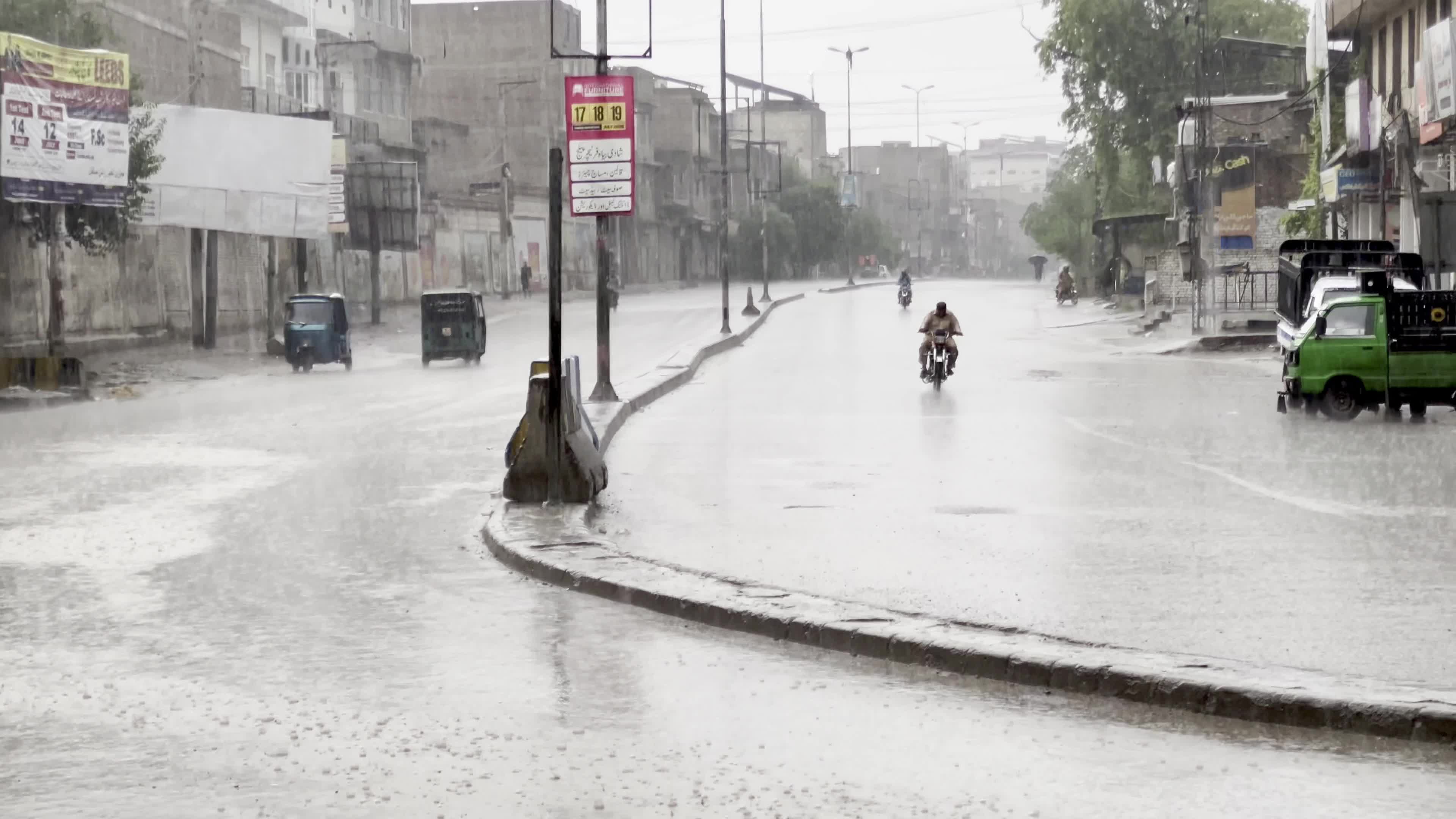 Vehicles make their way through heavy monsoon rain in Peshawar