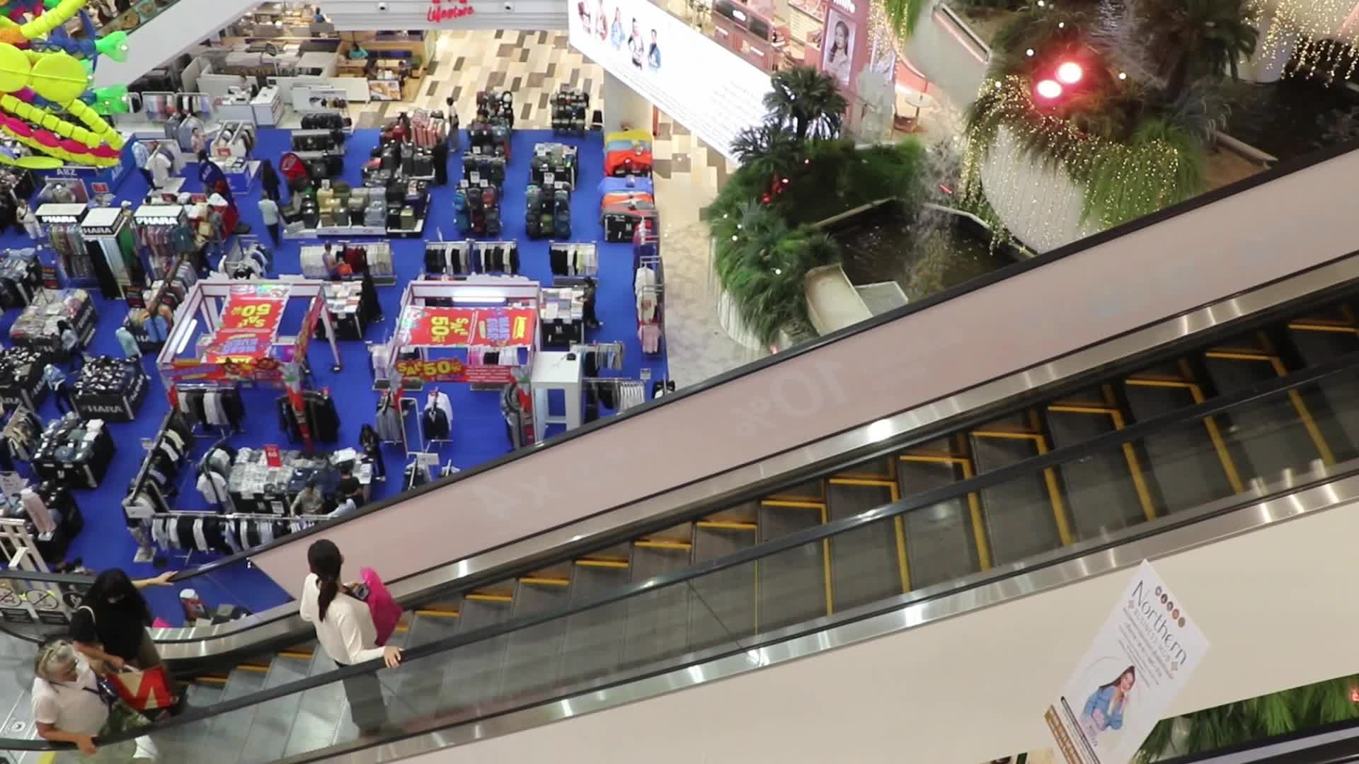 Tourists walk as they shop in the shopping mall in Bangkok.