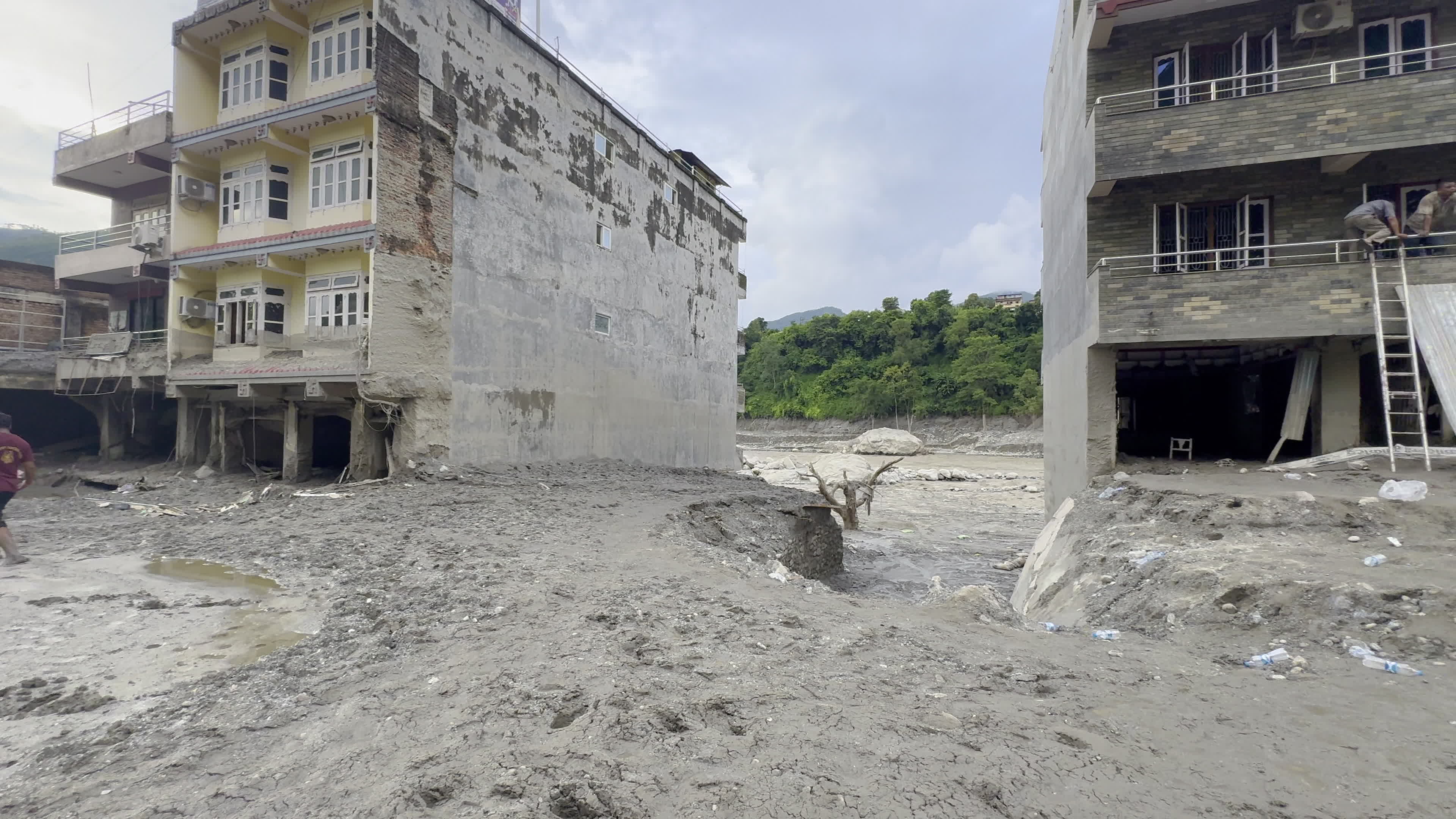 NEPAL: Residents Use Ladder to Access Precarious Building on Eroded Trishuli Riverbank