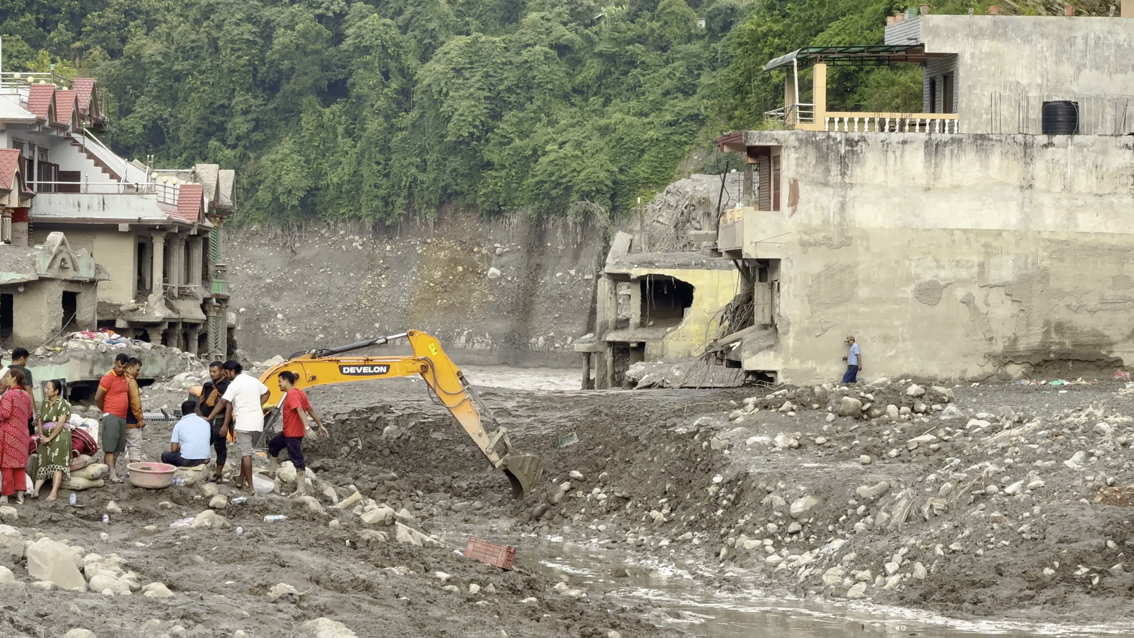 NEPAL: Heavy Excavator Clears River Mud and Debris Around Inundated Buildings in Trishuli