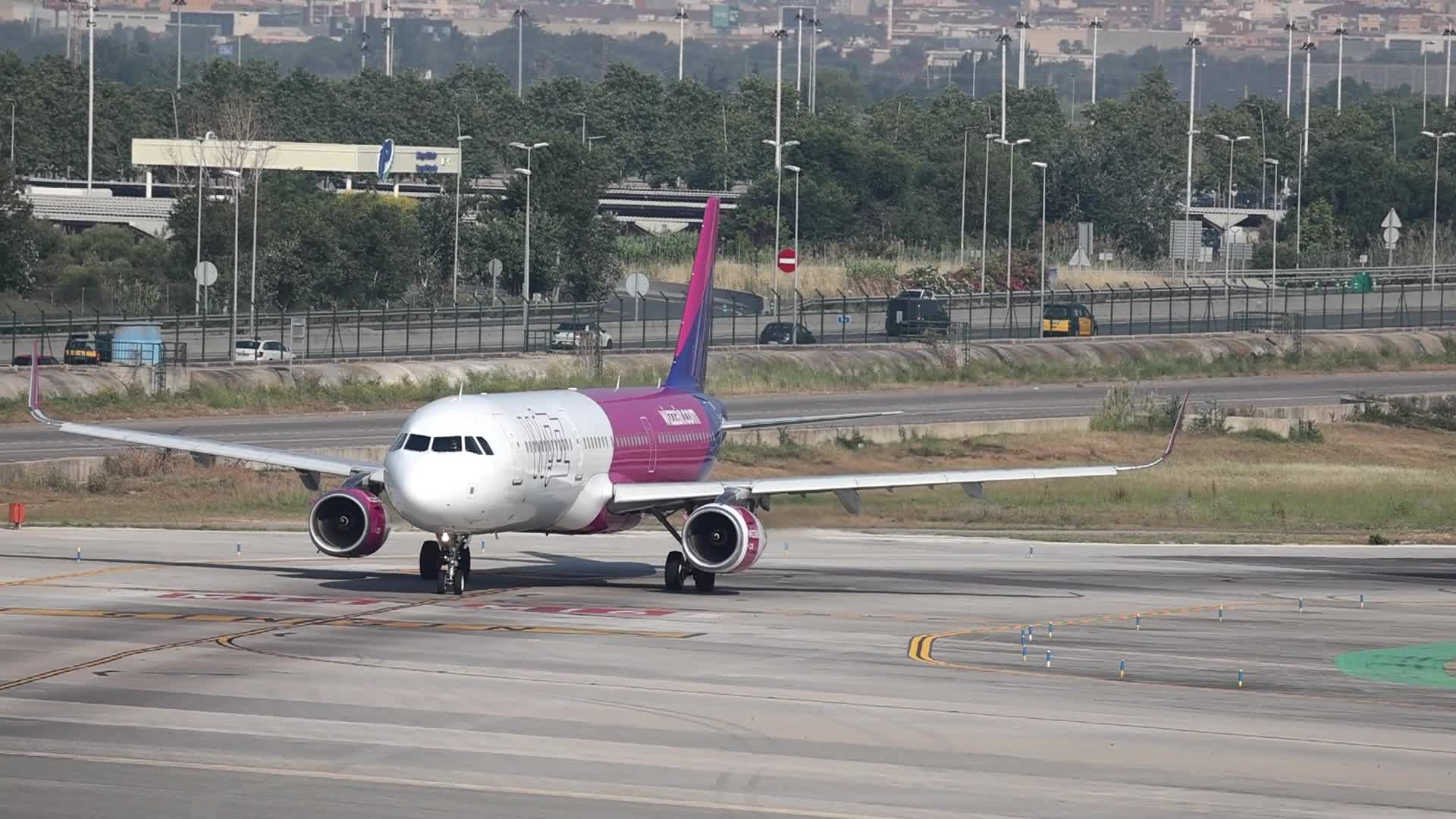 Wizz Air and PHS Premier aircraft on the runway at Barcelona Airport
