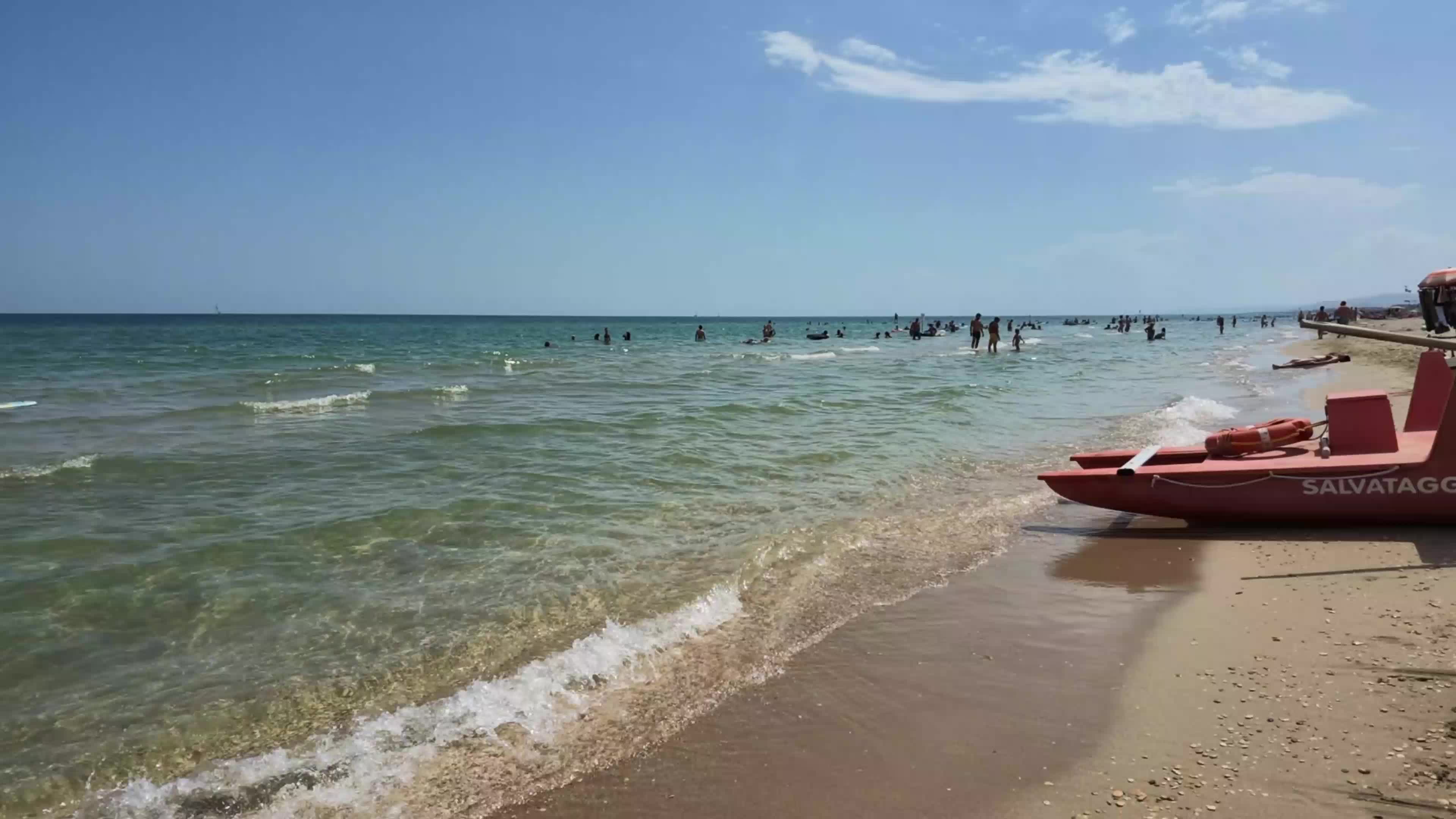 End of summer season on a quiet Italian beach with closed umbrellas and few people