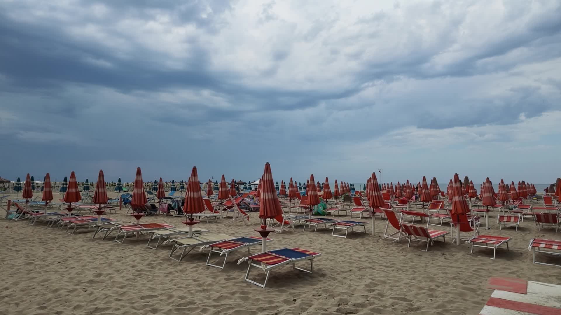 End of summer season on a quiet Italian beach with closed umbrellas and few people - 09/09/2026