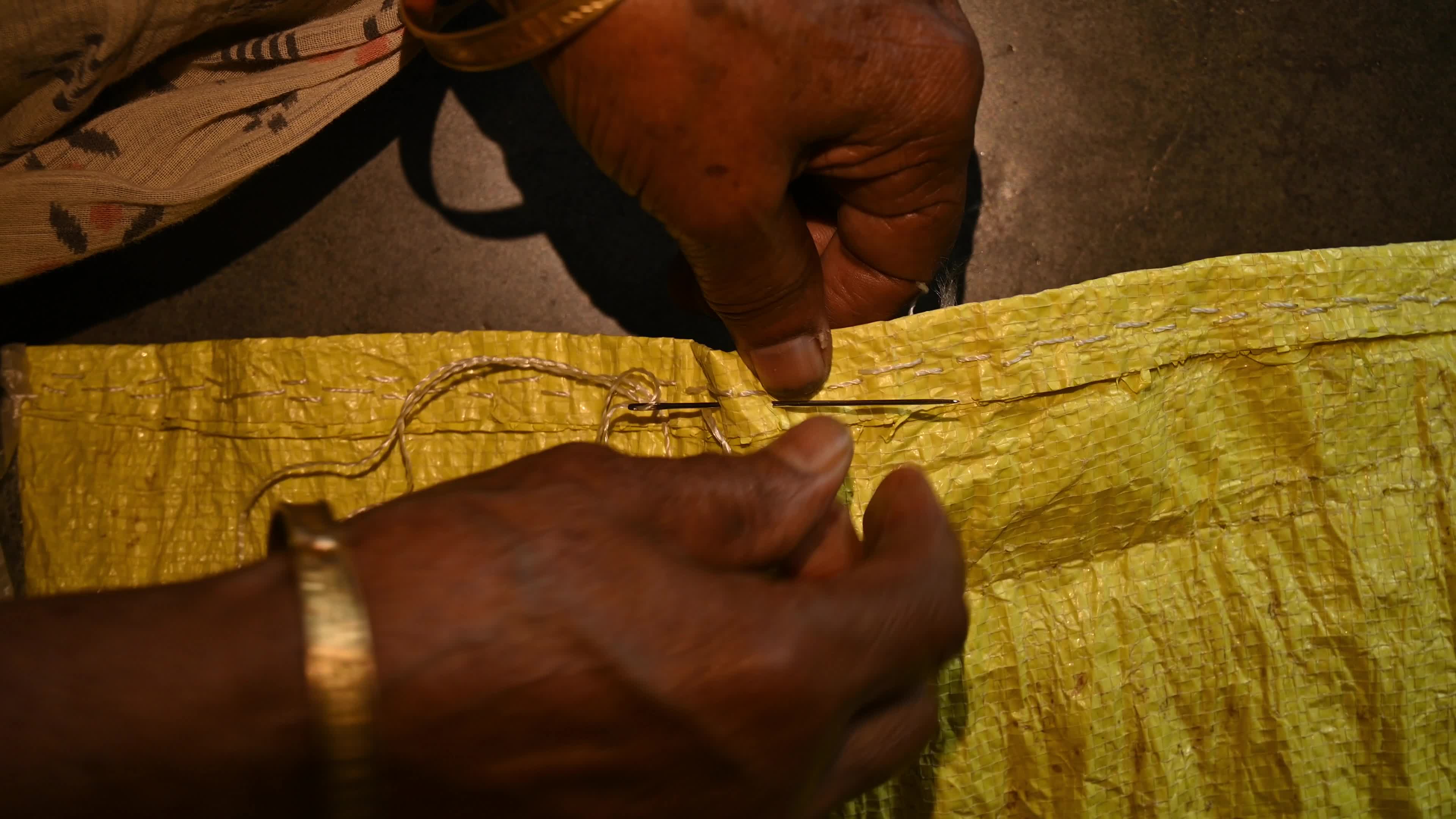 Manual sewing of a rice sack with thread - Sewing tool