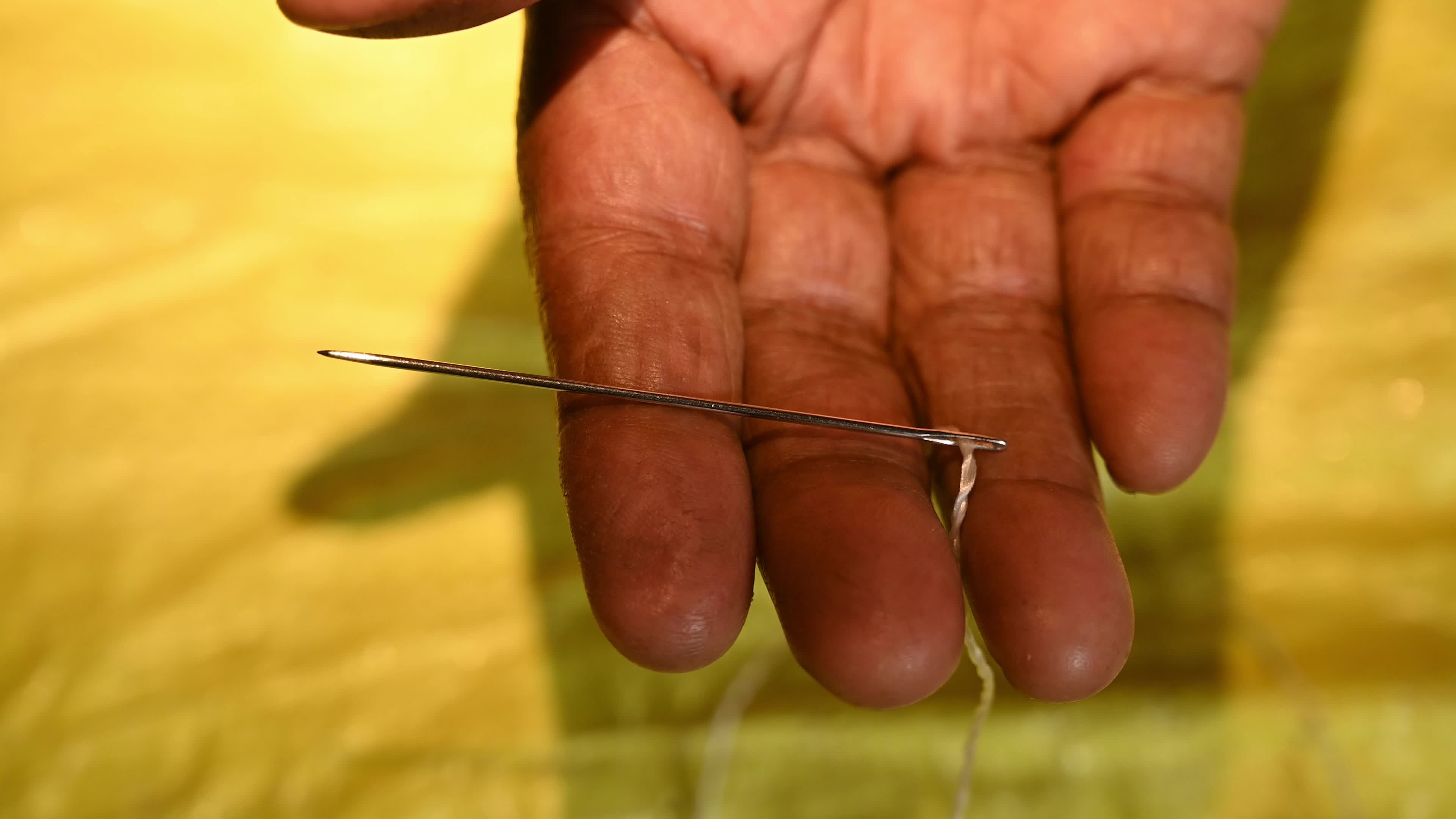 Manual sewing of a rice sack with thread - Sewing tool