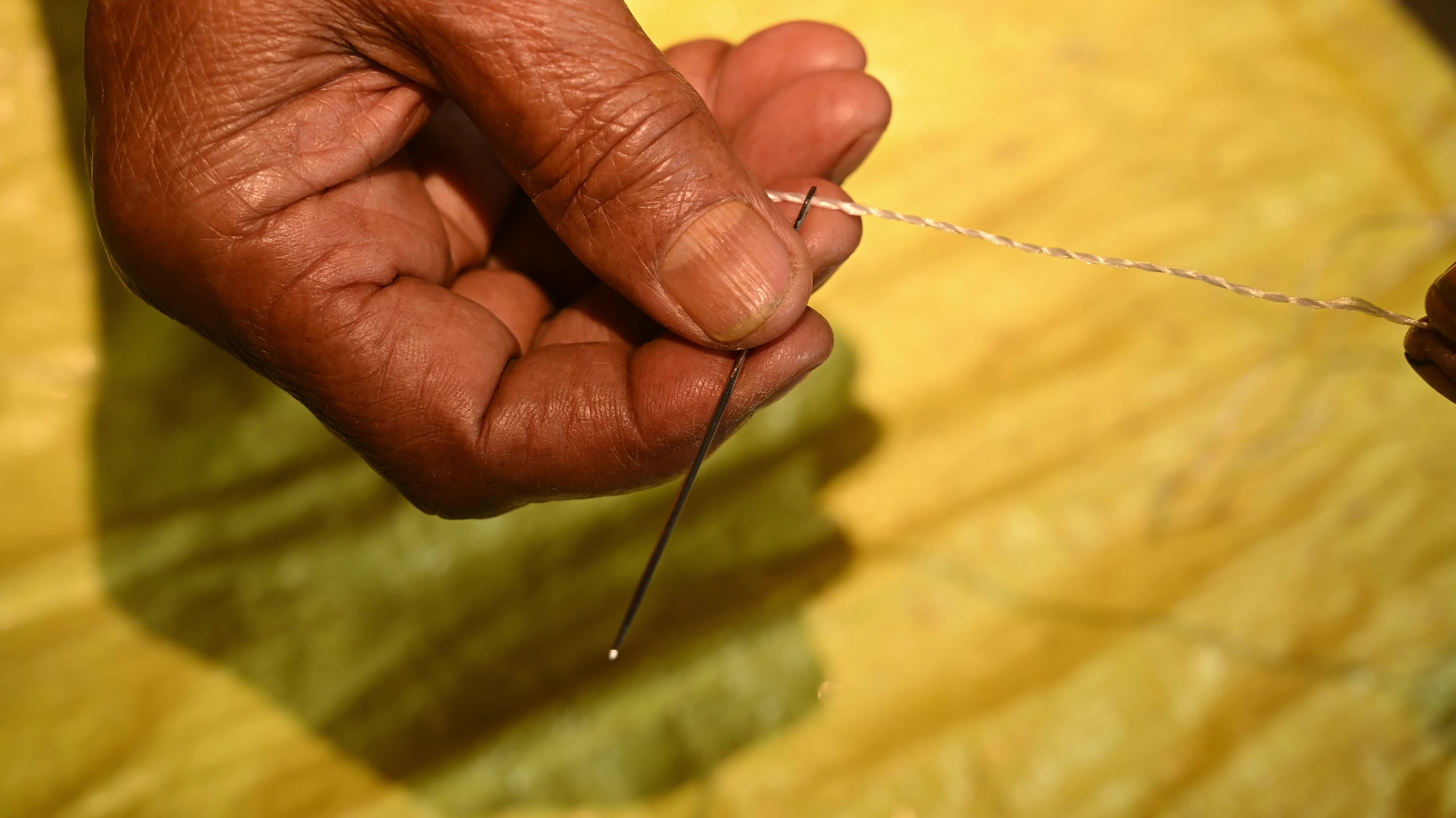 Manual sewing of a rice sack with thread - Sewing tool