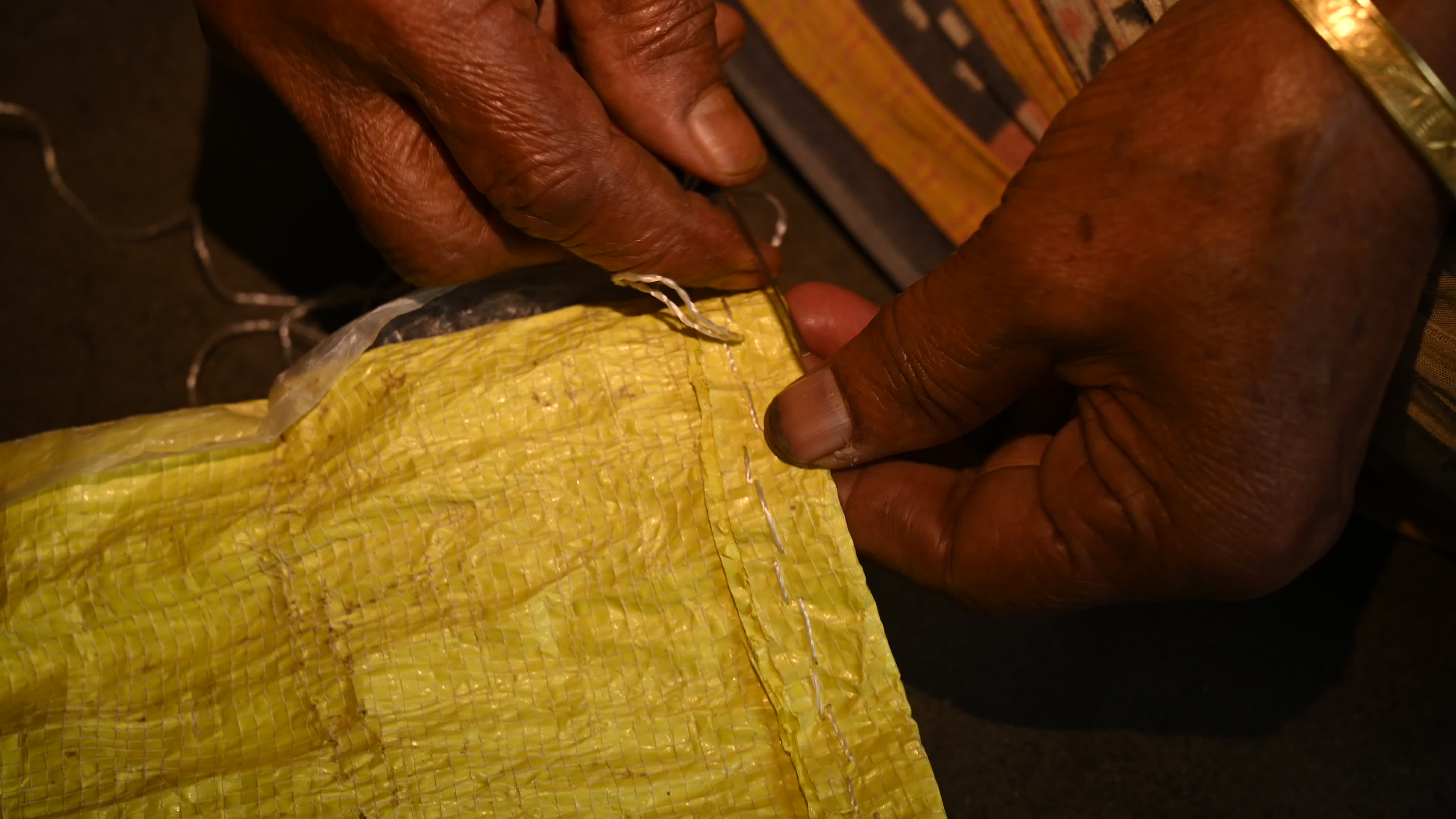 Manual sewing of a rice sack with thread - Sewing tool