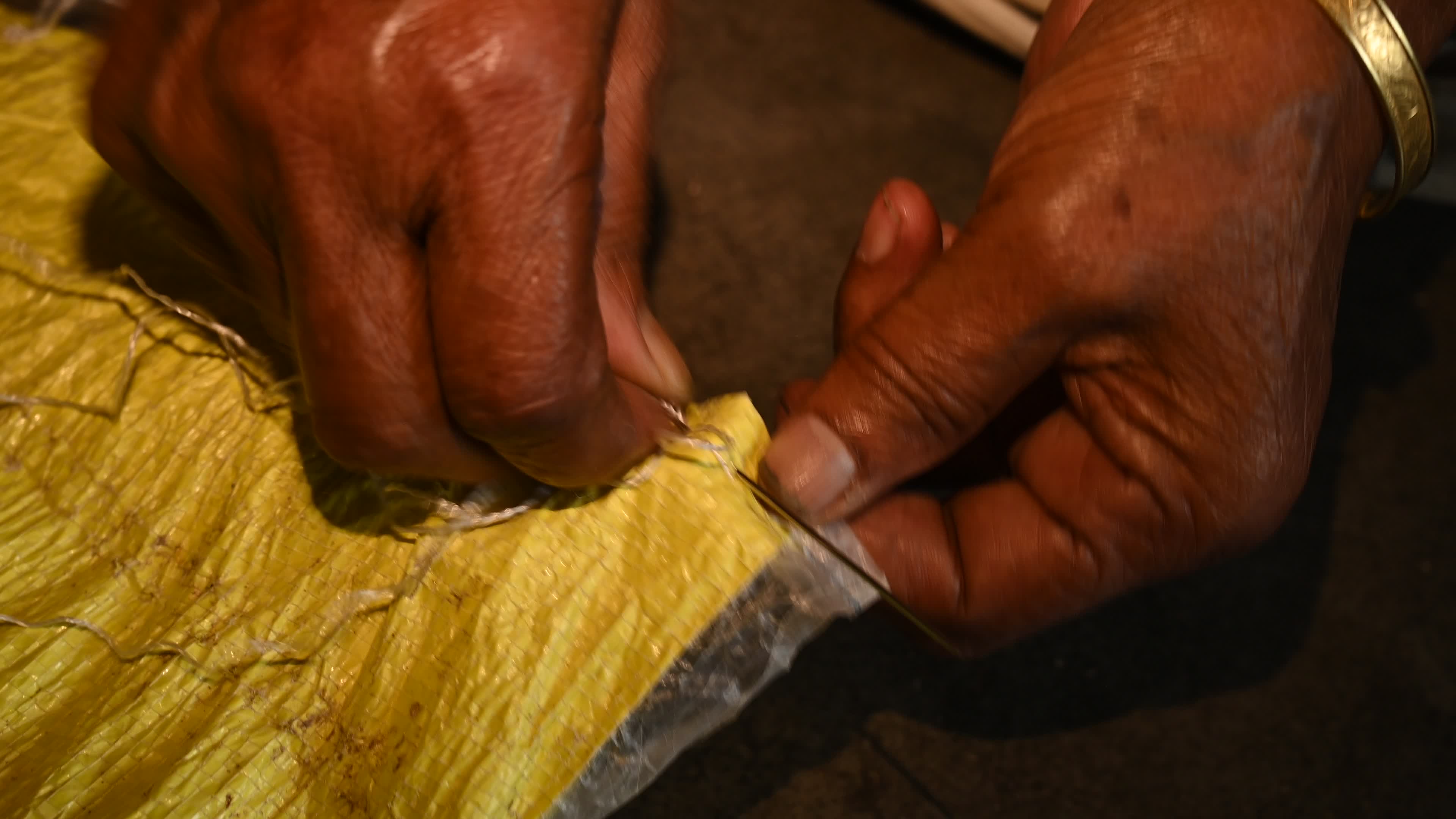 Manual sewing of a rice sack with thread - Sewing tool