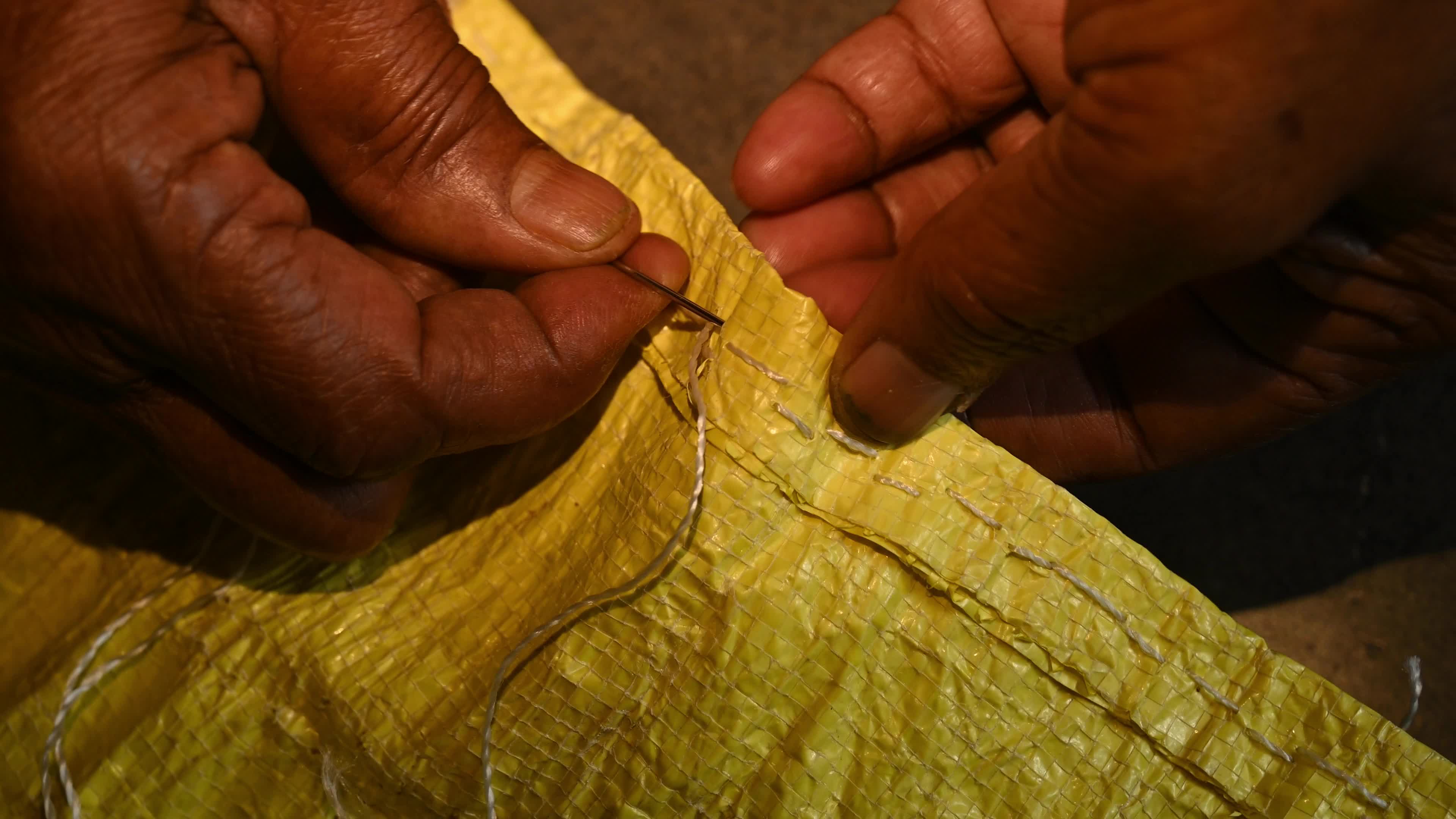 Manual sewing of a rice sack with thread - Sewing tool