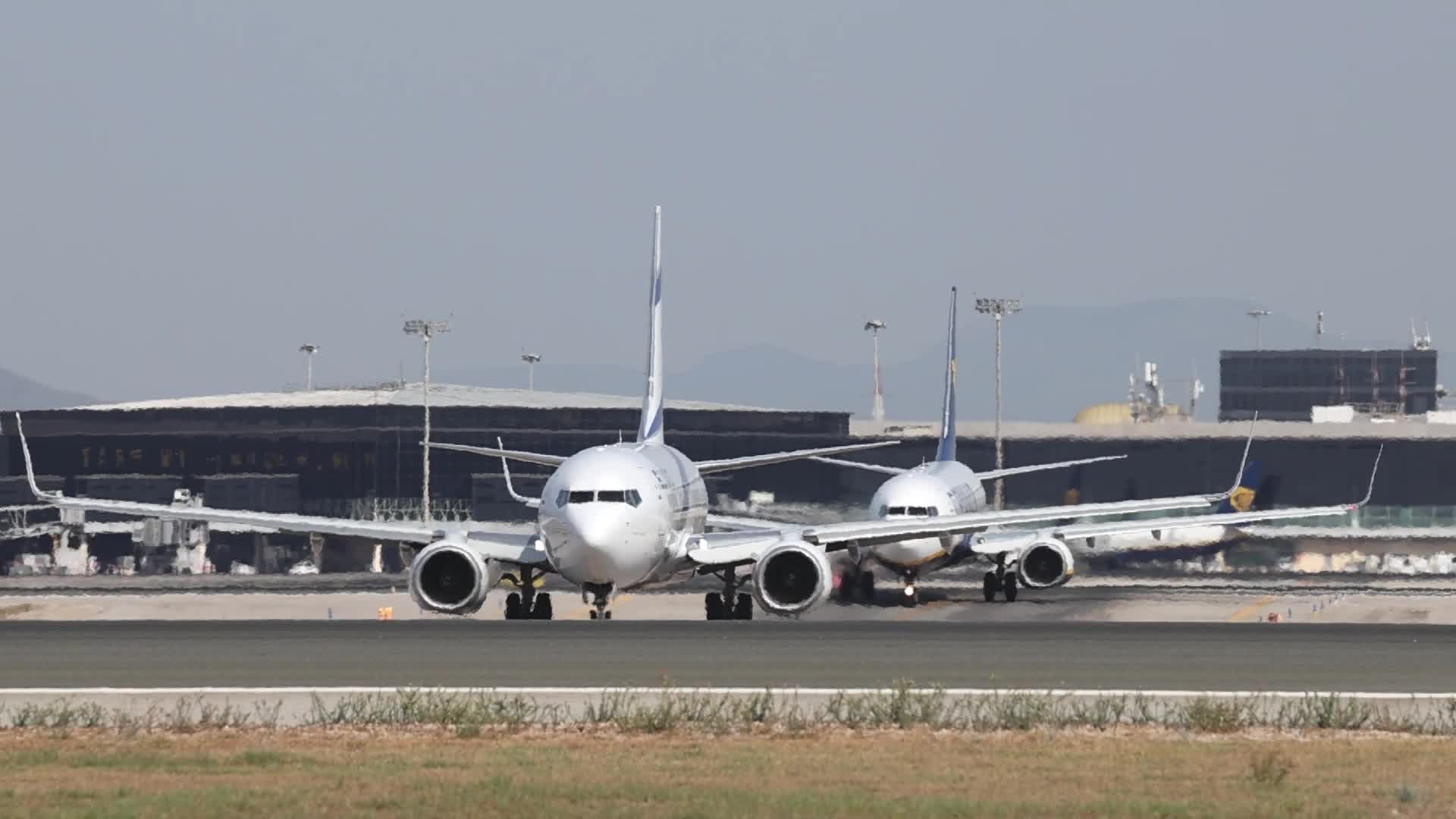 An El Al and a Raynair aircraft prepare to takeoff from Barcelona Airport