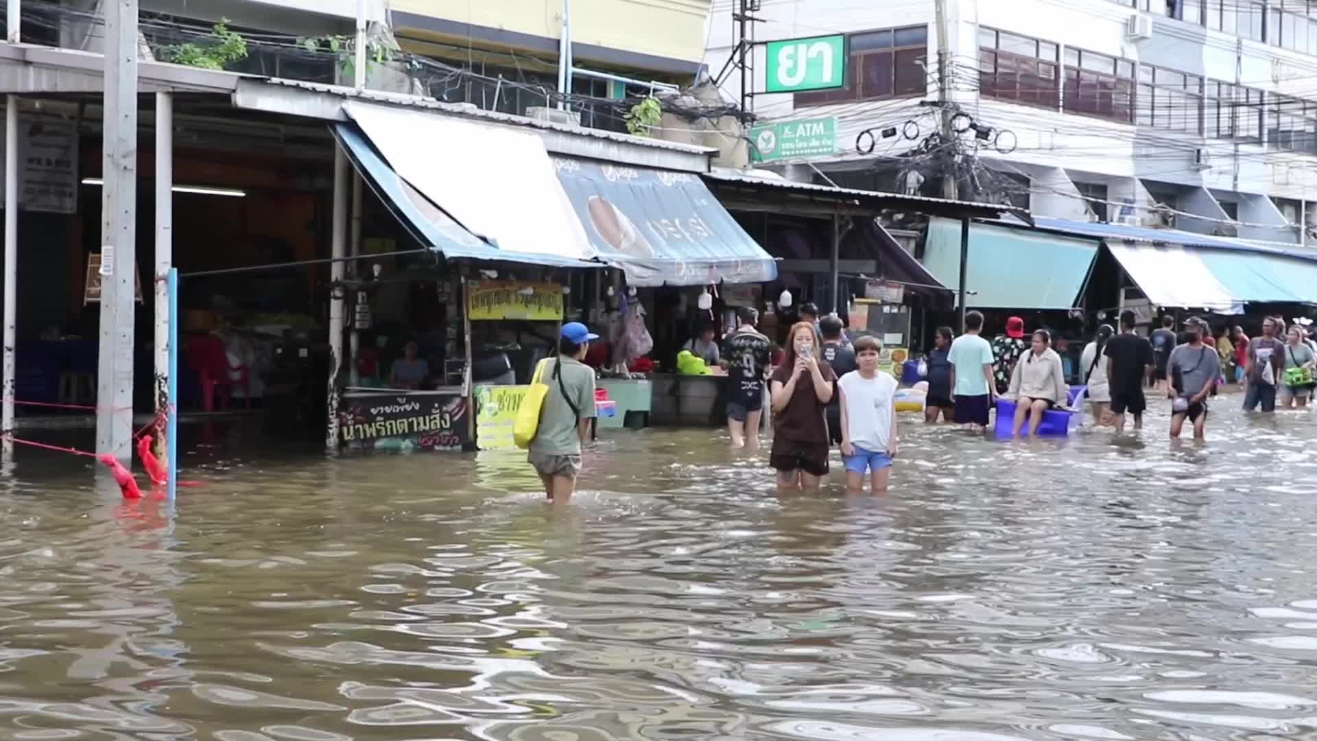 Bangkok residents walk in floodwater.