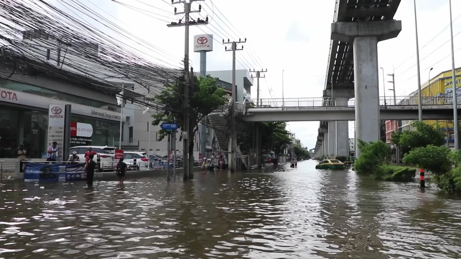 Bangkok residents walk in floodwater.