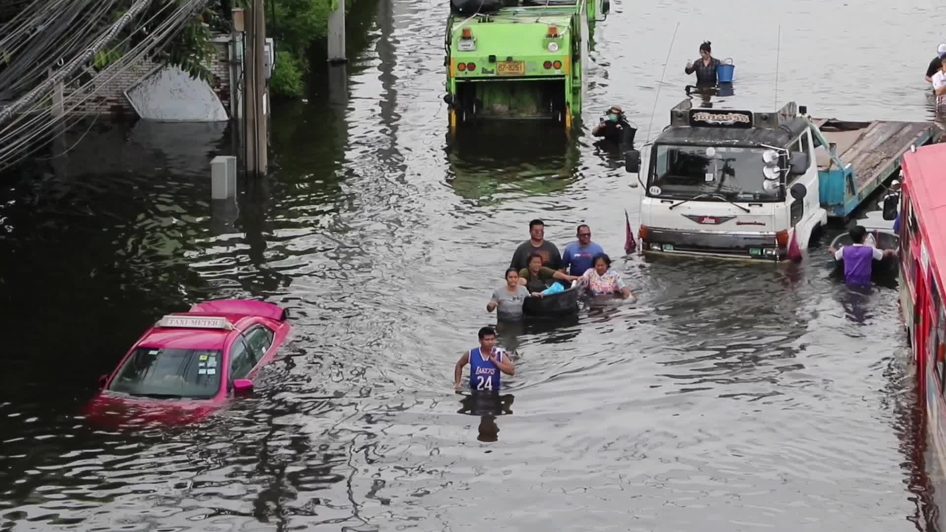 Bangkok residents walk in floodwater.