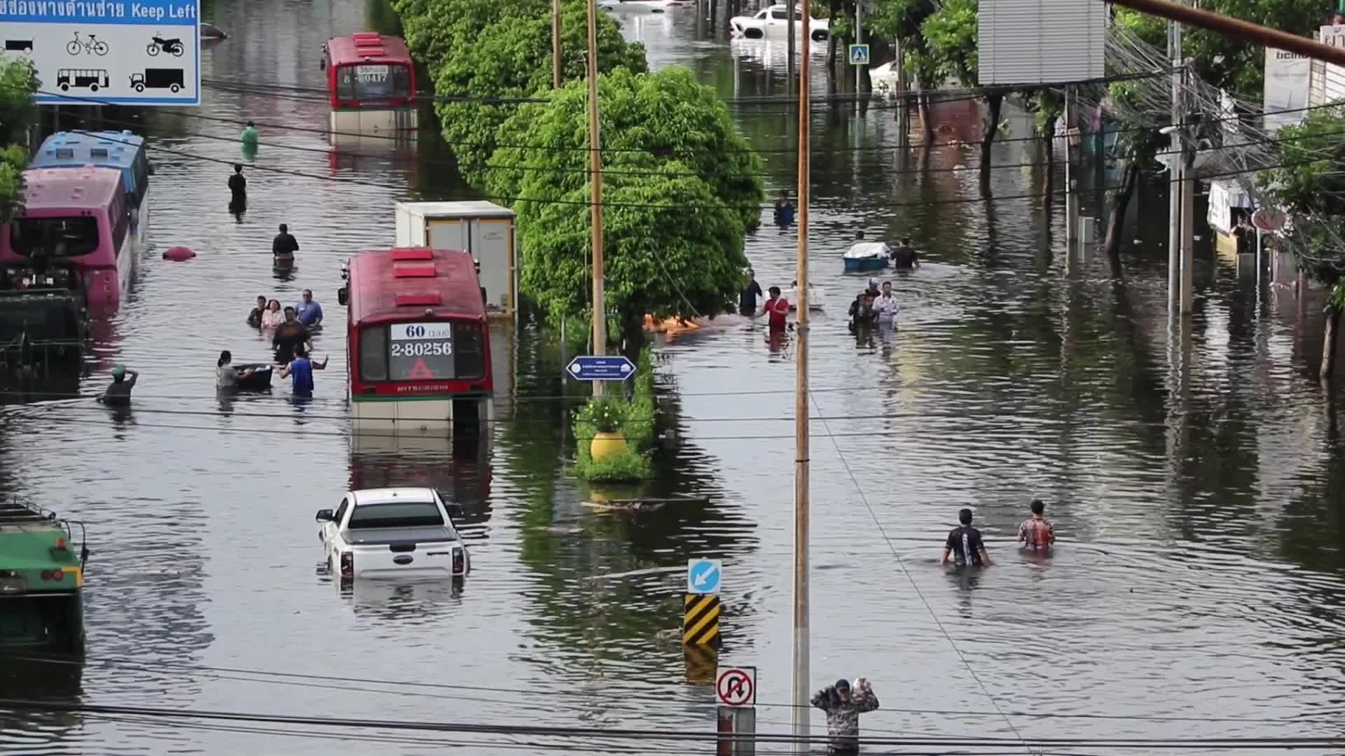 Bangkok residents walk in floodwater.