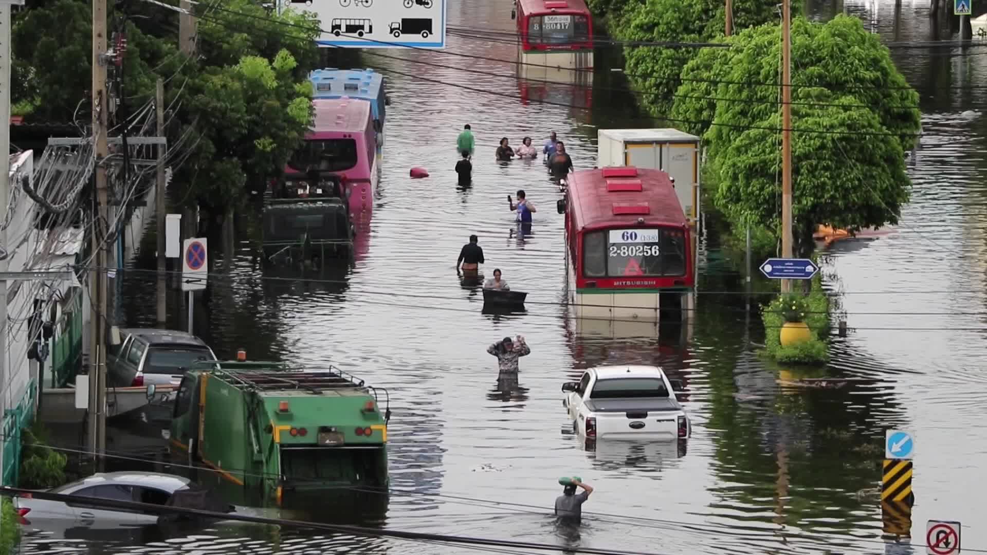 Bangkok residents walk in floodwater.