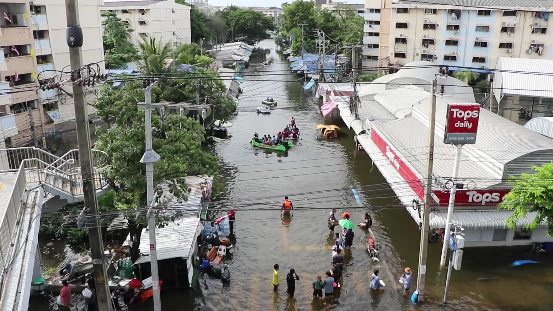 Bangkok residents walk in floodwater.