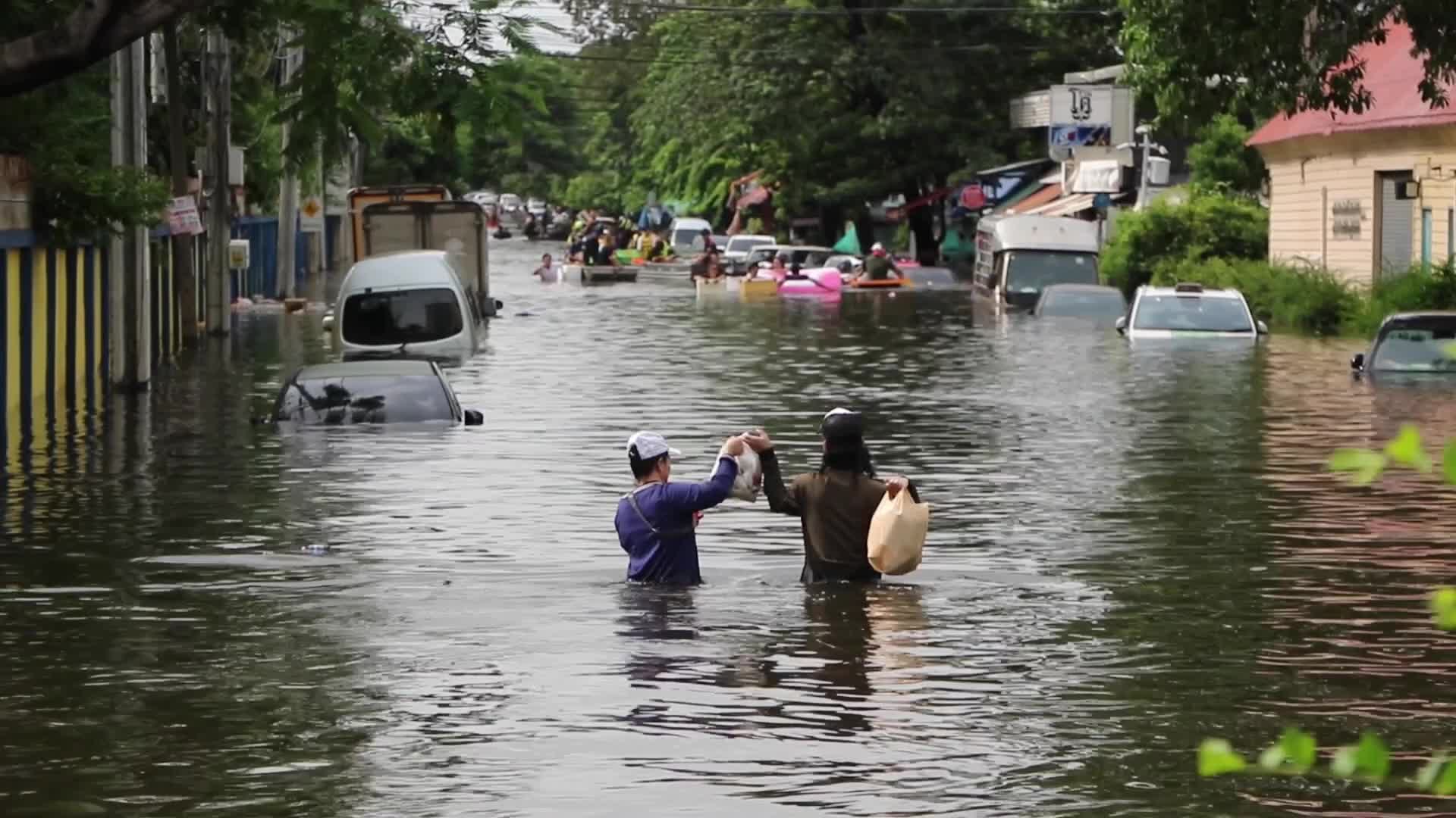 Bangkok residents walk in floodwater.