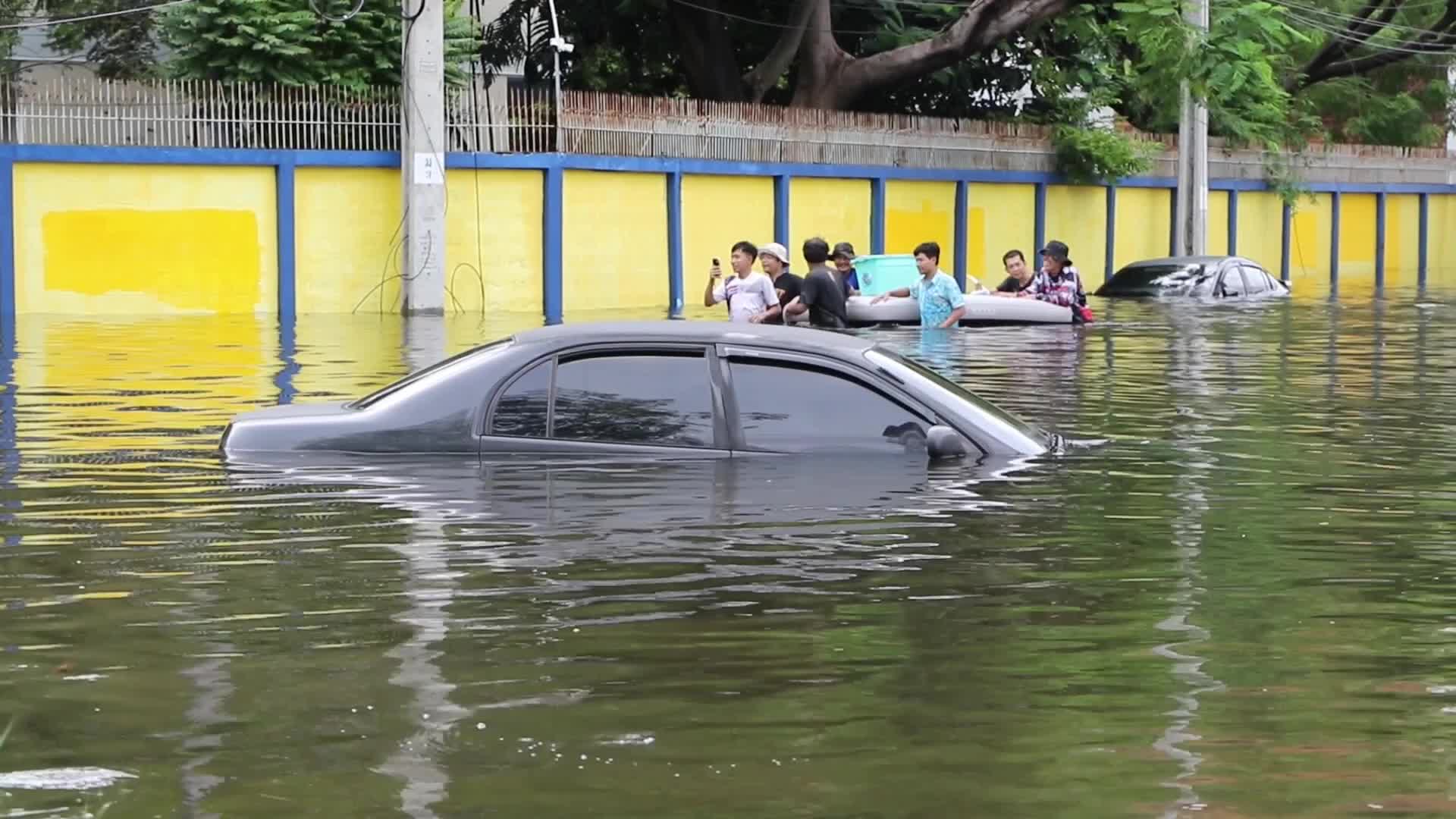 Bangkok residents walk in floodwater.
