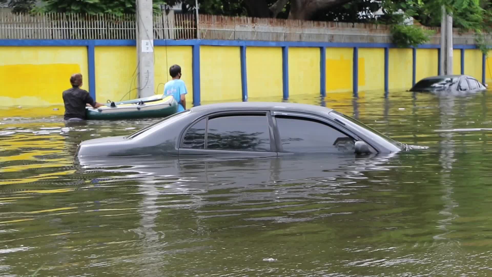 Bangkok residents walk in floodwater.