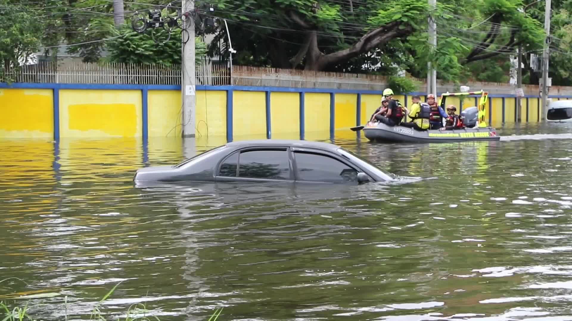 Bangkok residents and rescue team sit on boat.
