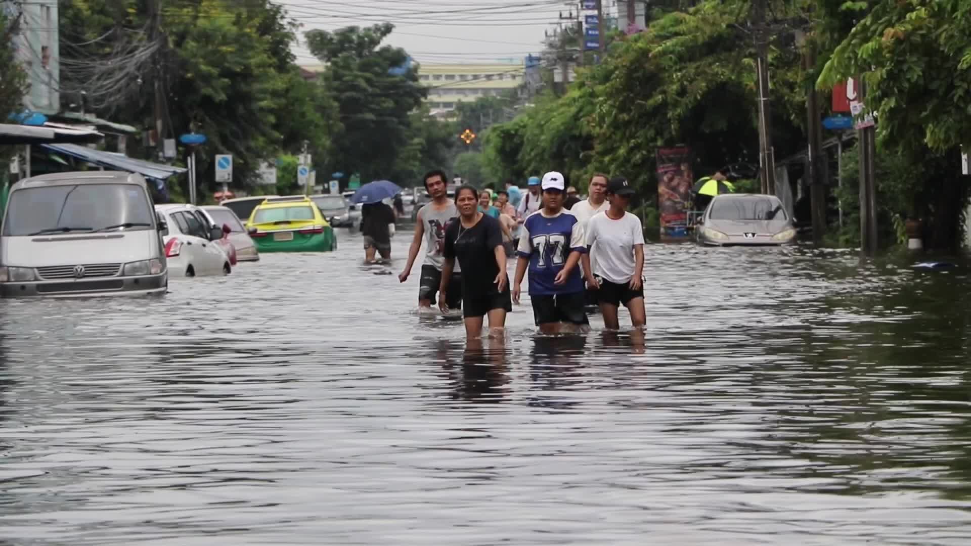 Bangkok residents walk in floodwater