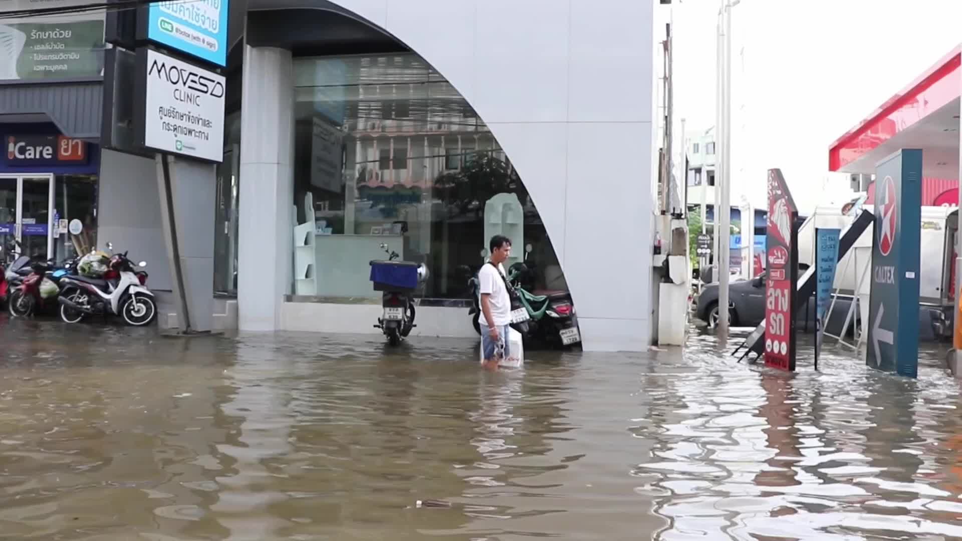 Bangkok resident walks in floodwater.