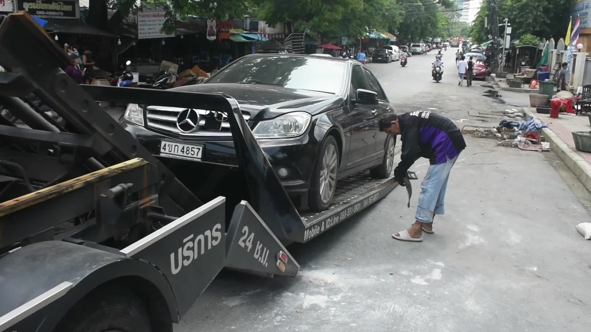 Residents evacuate their damage vehicles after heavy floods in Bangkok.
