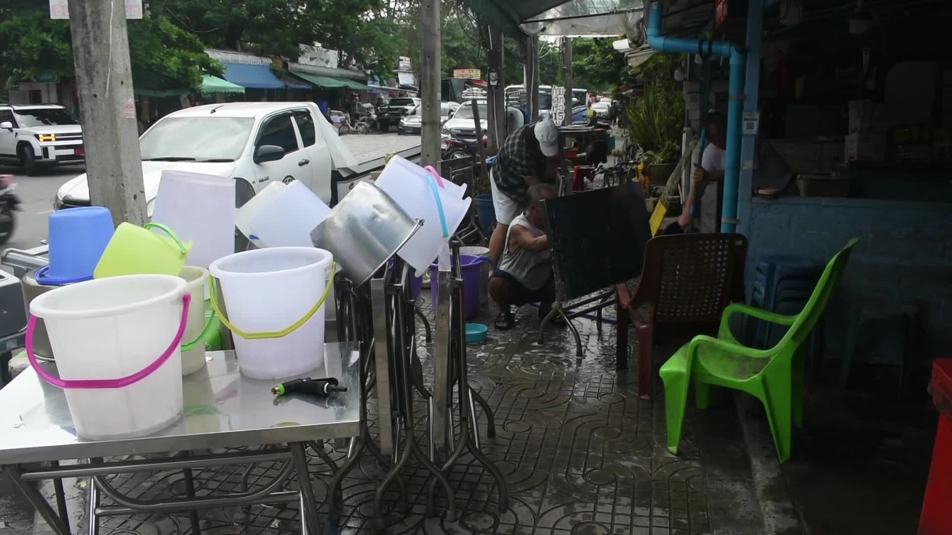 Restaurant workers clean their shops after floods in Bangkok.